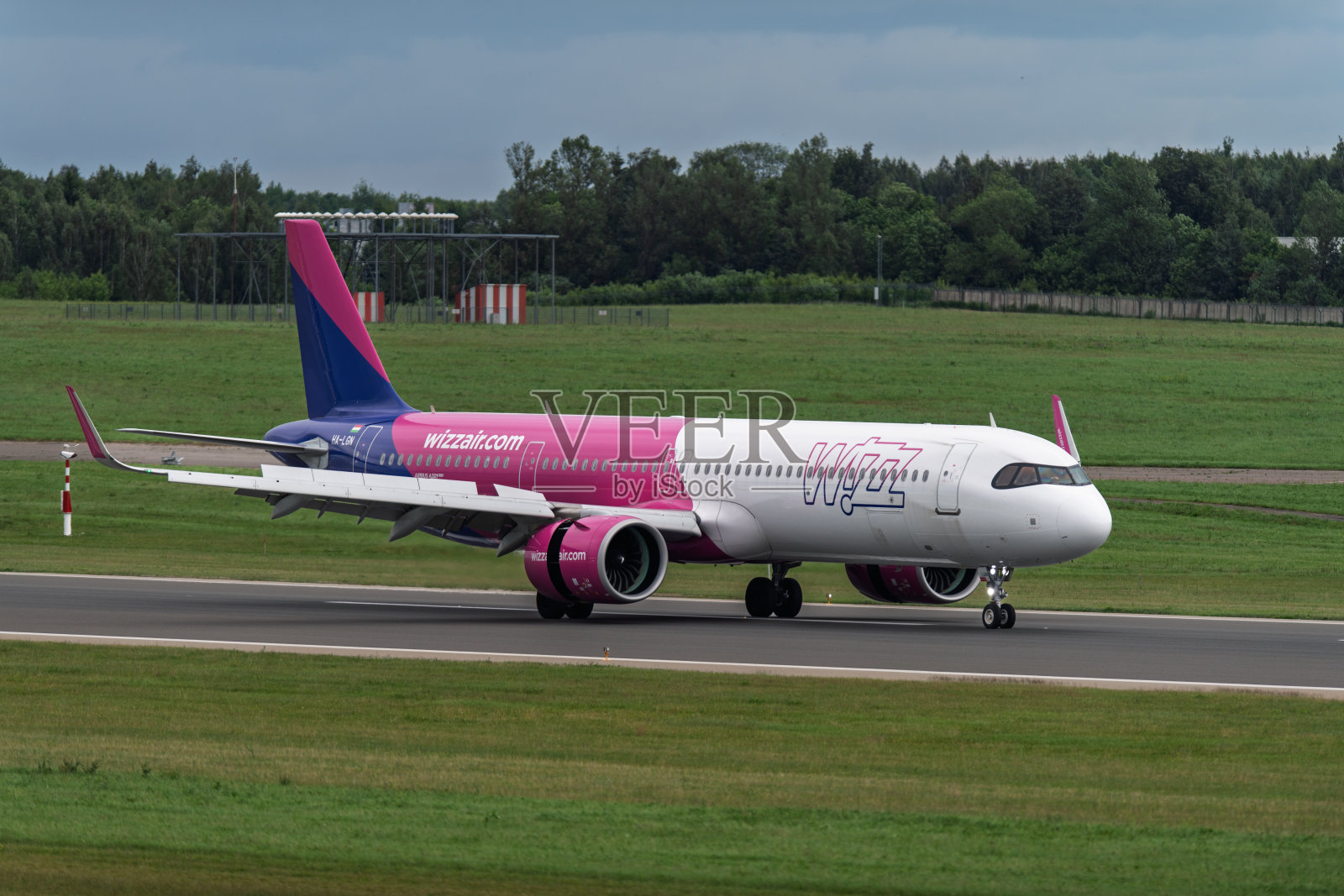 商业空客A321 Wizz Air客机在立陶宛维尔纽斯机场的跑道上，靠近天气雷达塔照片摄影图片