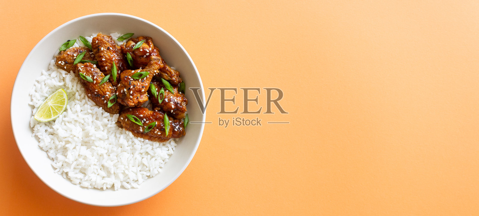 照烧酱鸡翅配米饭、芝麻和洋葱。亚洲美食。照片摄影图片