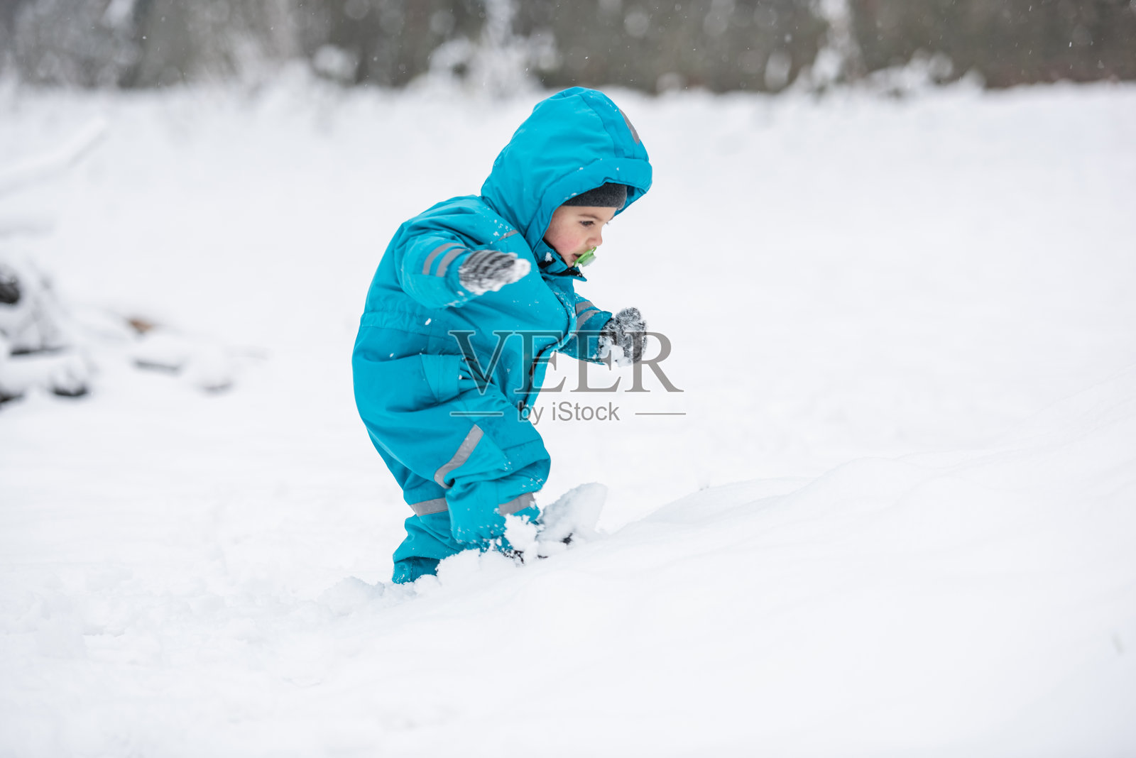 幼儿在冬日的深雪中行走照片摄影图片
