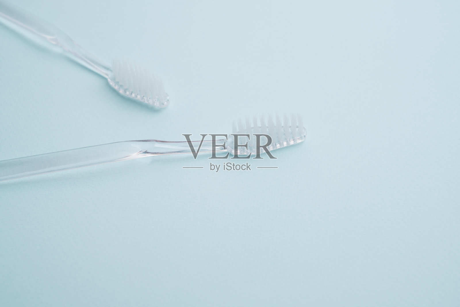 白色牙刷在彩色背景上。用新牙刷替换旧牙刷。旧牙刷和新牙刷。口腔健康与卫生概念照片摄影图片