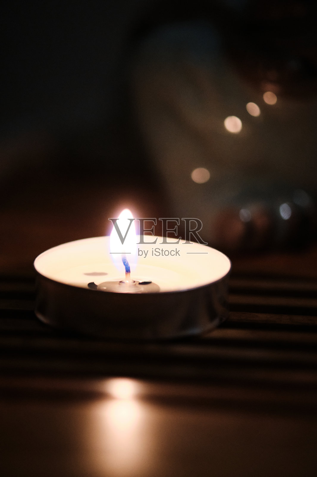 黑暗中燃烧的单个茶蜡烛照片摄影图片