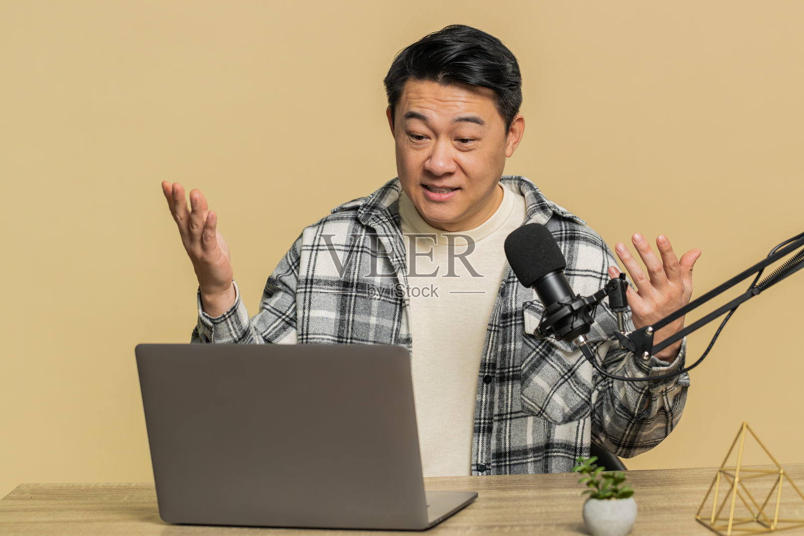 男性博主影响者正在录制播客，进行研讨会，通过麦克风和笔记本电脑发言。照片摄影图片