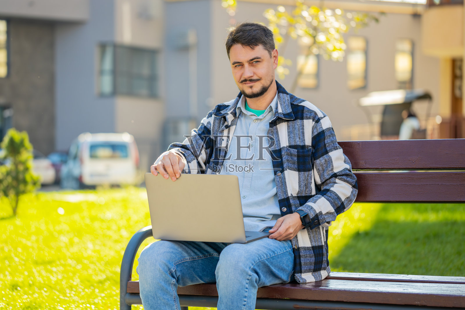 白人成熟男性自由职业者在城市长椅上使用笔记本电脑远程工作照片摄影图片