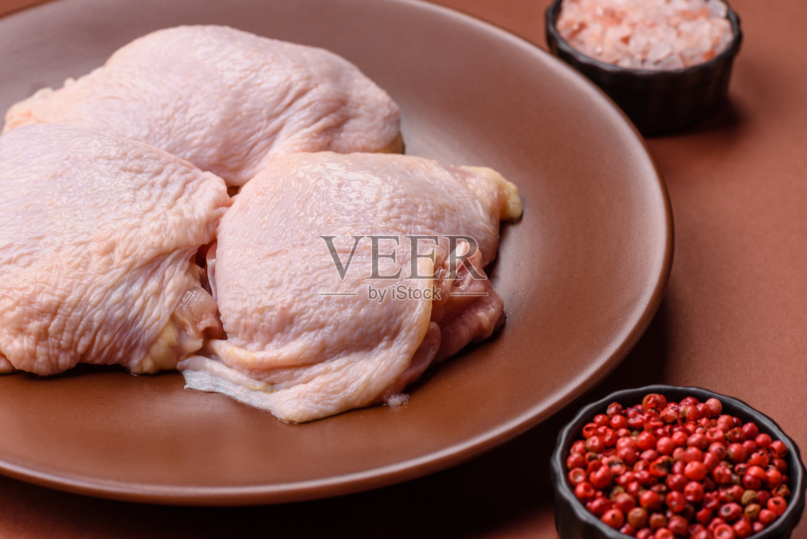 生鸡腿，鲜嫩的家禽肉，配有盐和香料照片摄影图片