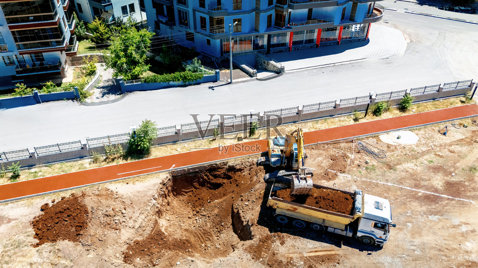 无人机航拍画面，挖掘机将土壤装入卡车中照片摄影图片