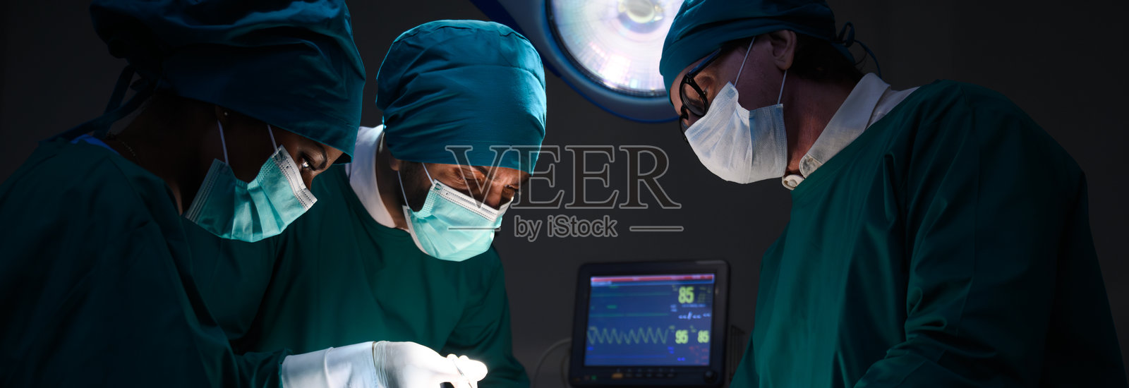 一组专注的外科医生团队在医院手术室进行手术。专业的医疗团队正在进行关键手术。照片摄影图片