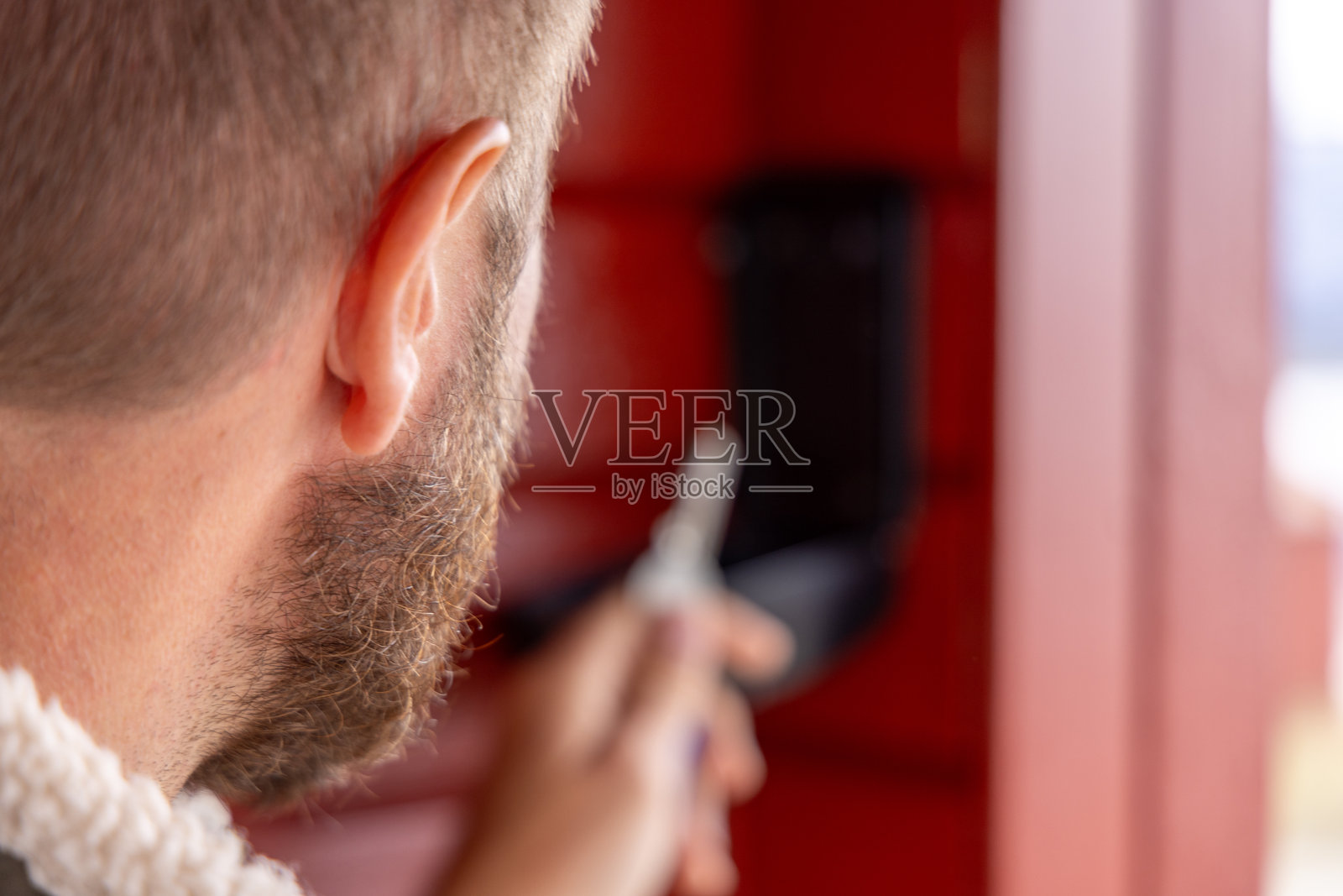 在木墙上打开户外钥匙保险箱的人照片摄影图片