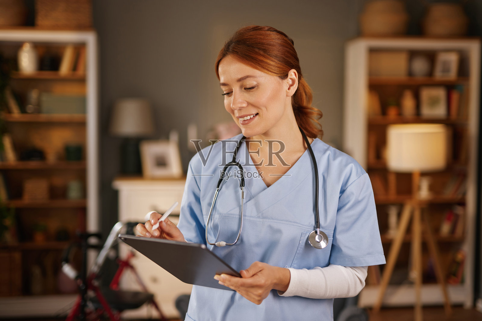 微笑的护士在家访时用数字平板记录笔记照片摄影图片