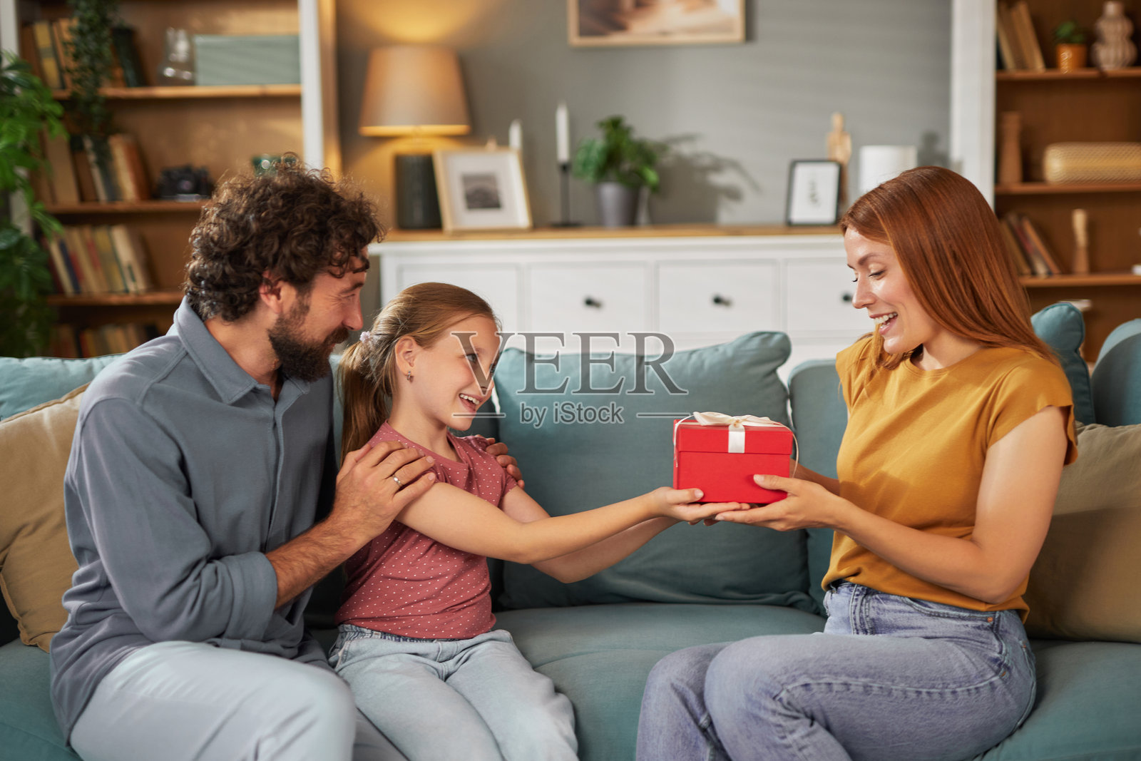快乐的家庭在沙发上互赠礼物照片摄影图片