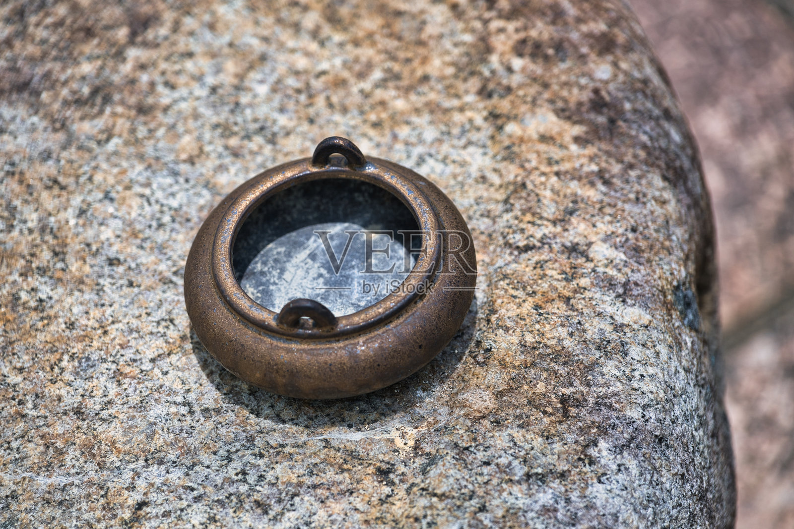 一枚古老的金属戒指静静地放在岩石上照片摄影图片
