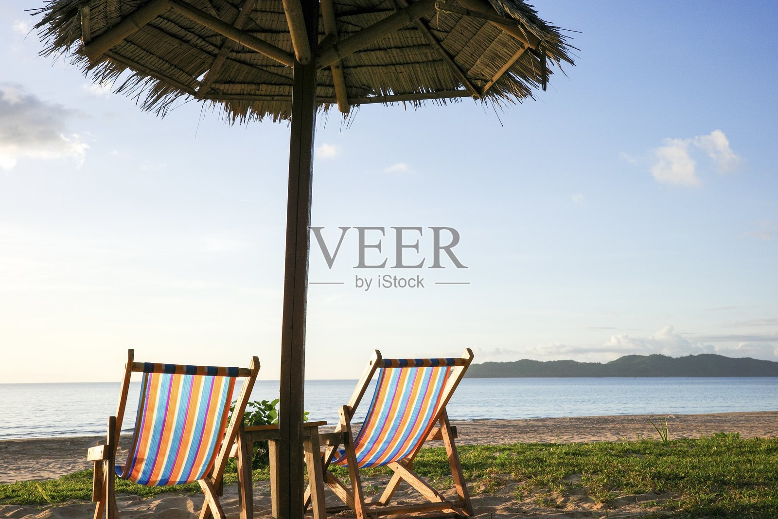 菲律宾巴拉望省埃尔尼多的美丽热带躺椅和草伞旁的海洋照片摄影图片