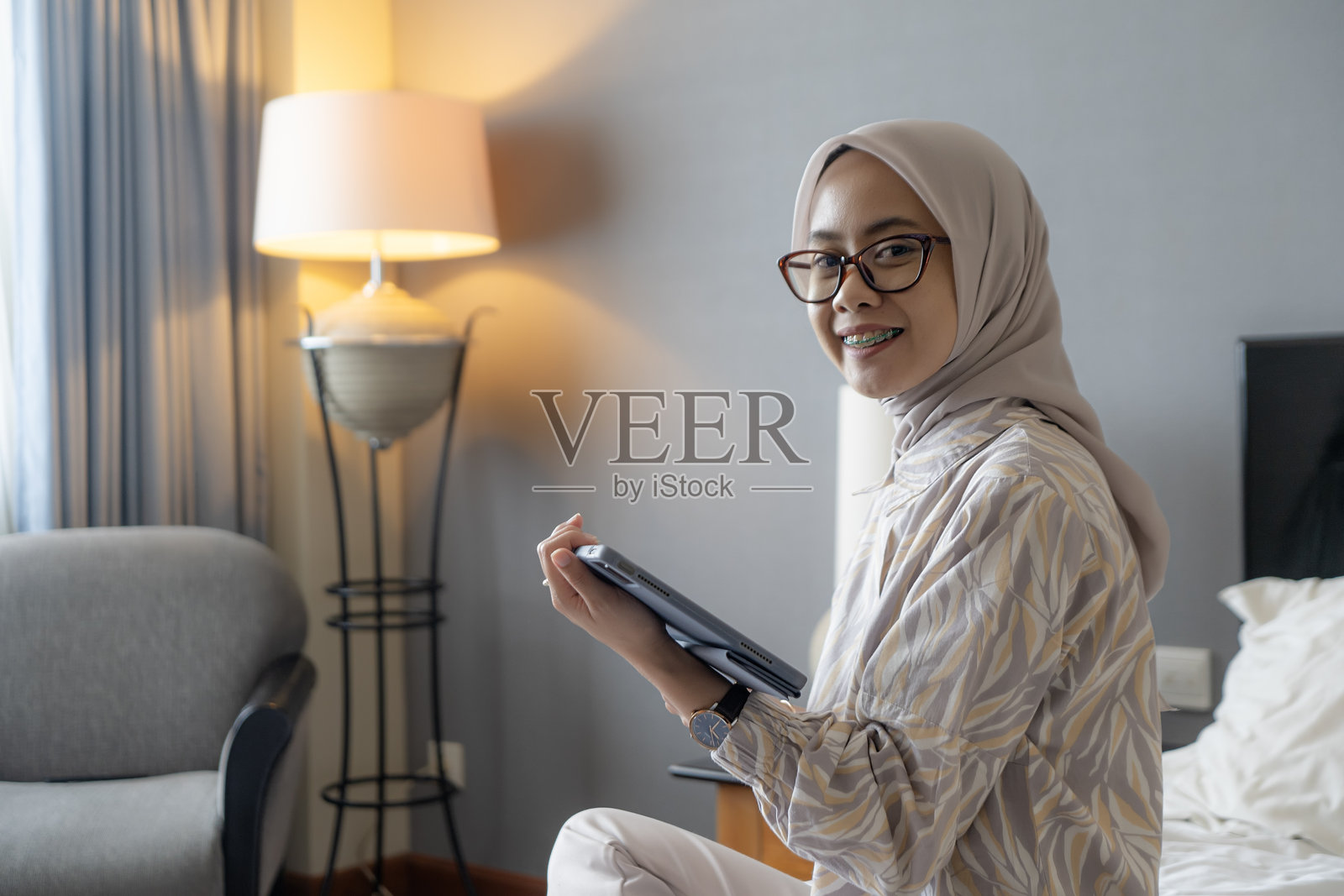 微笑的亚洲印尼女性在家中使用平板电脑照片摄影图片