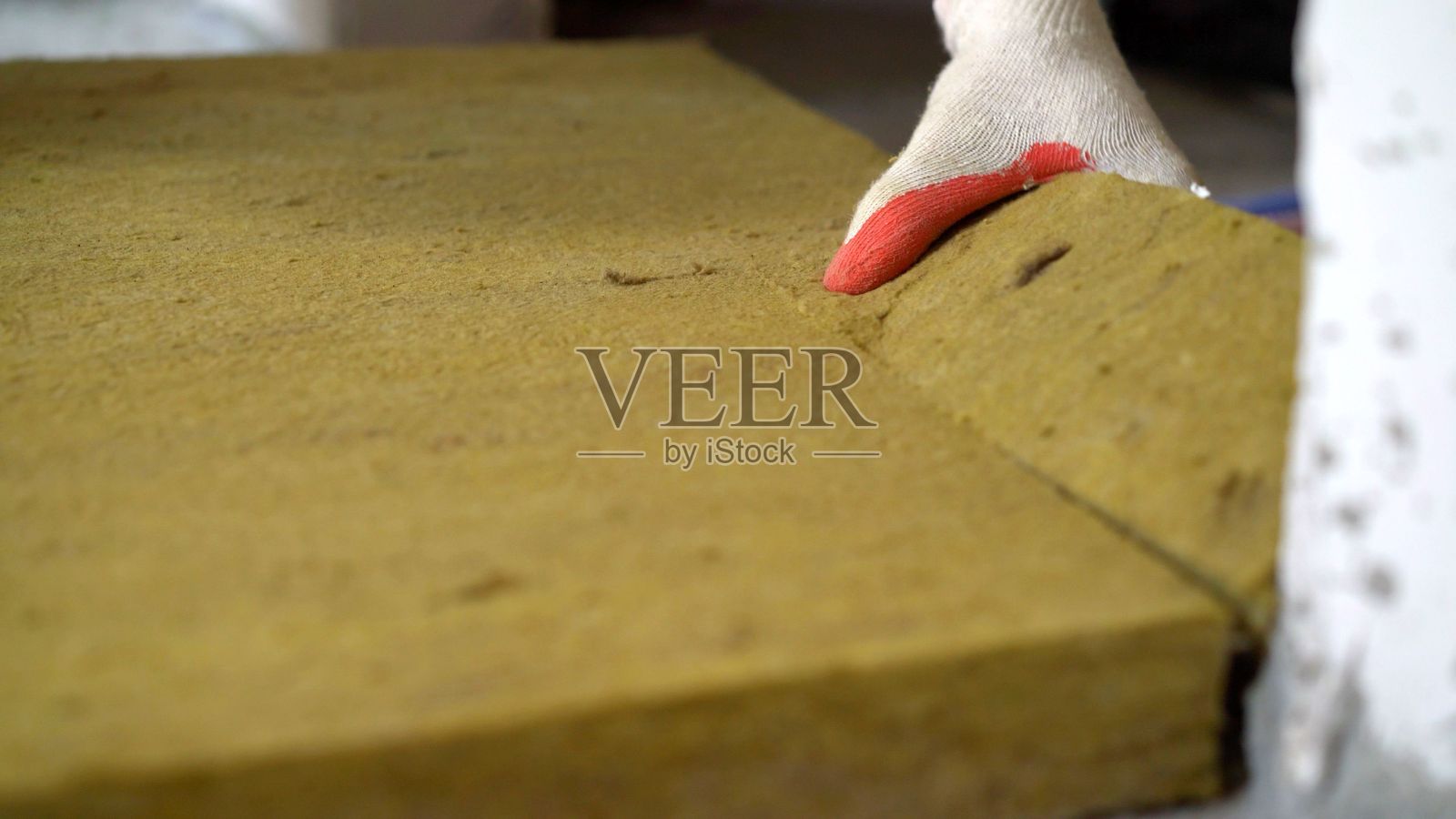 公寓里的黄色玻璃棉。新公寓的地板上铺设隔音玻璃棉。照片摄影图片