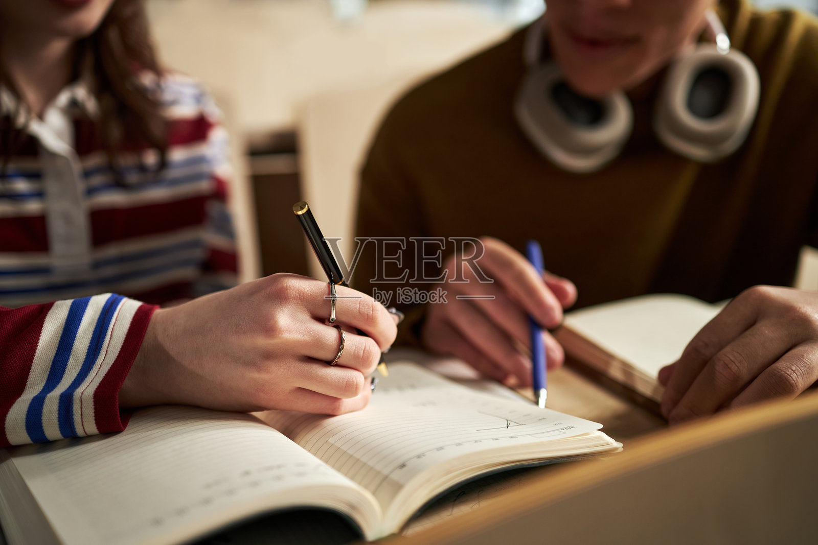 大学图书馆中学生们合作完成作业的手部特写照片摄影图片