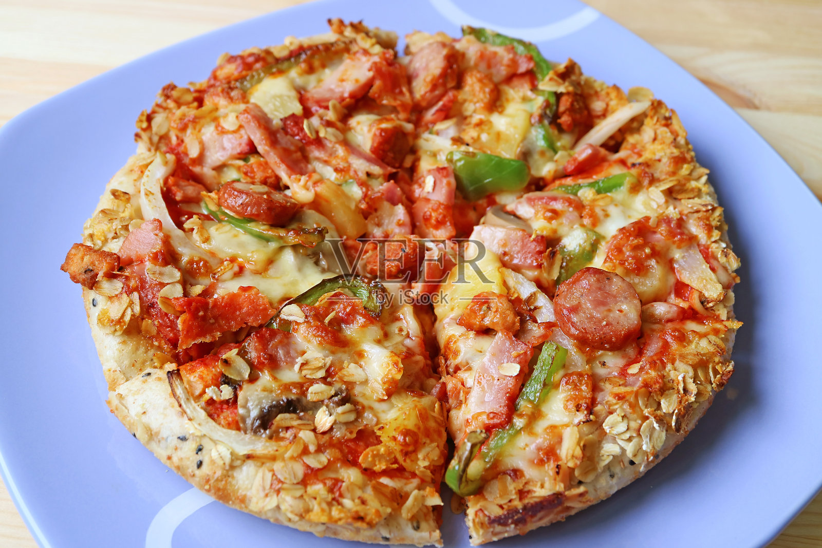 木桌上的美味意大利香肠混合蔬菜披萨盘照片摄影图片