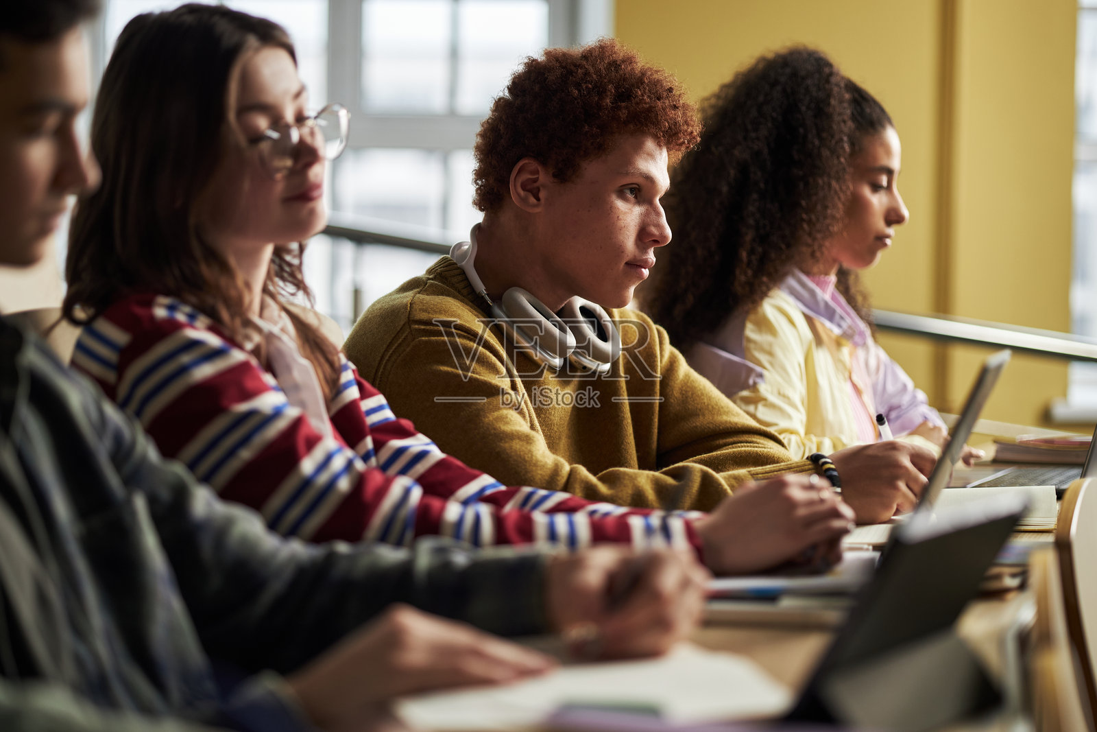 多民族年轻大学生在大学研讨会上听讲和写作照片摄影图片