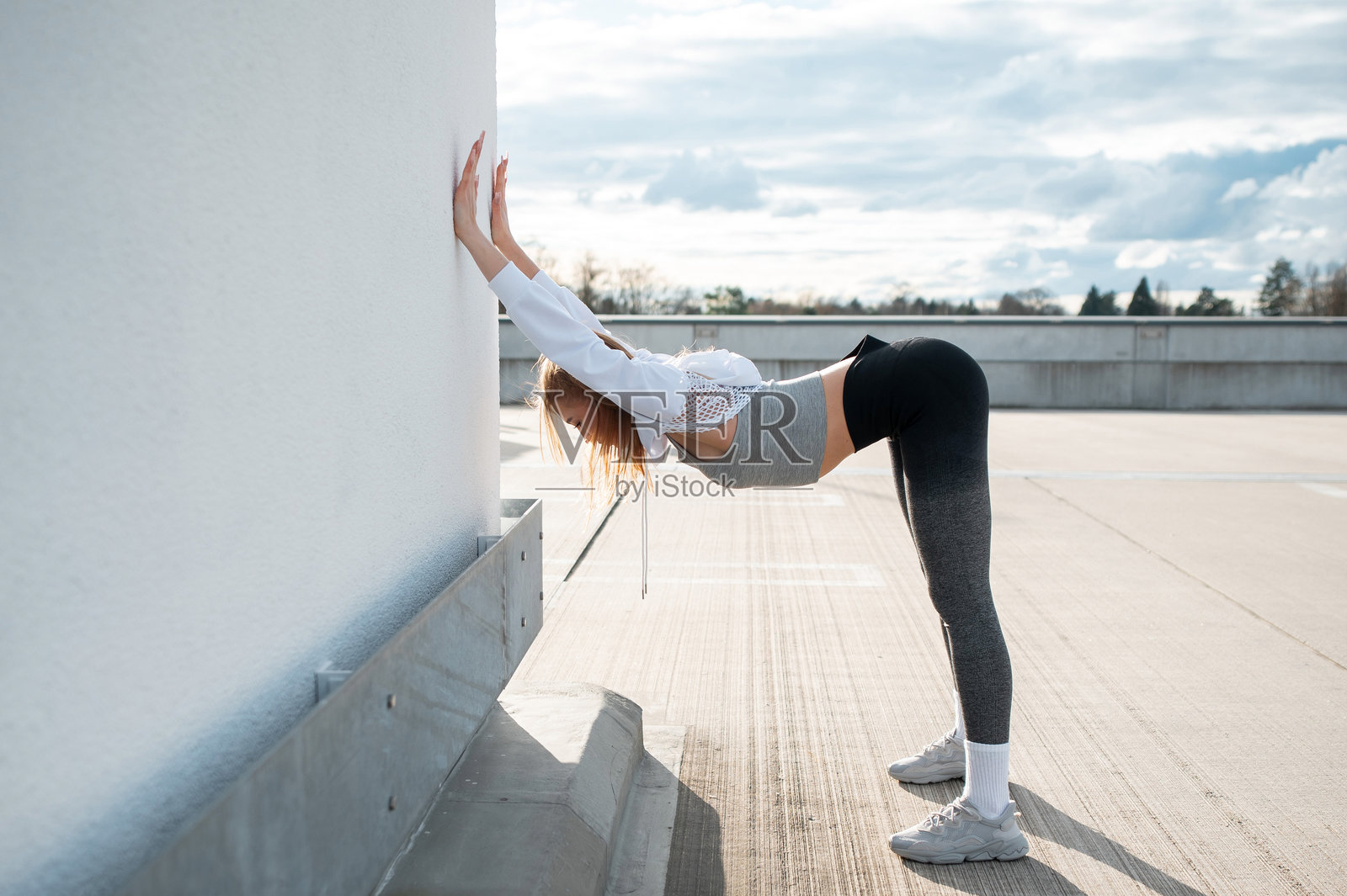 年轻女性在屋顶上伸展身体照片摄影图片