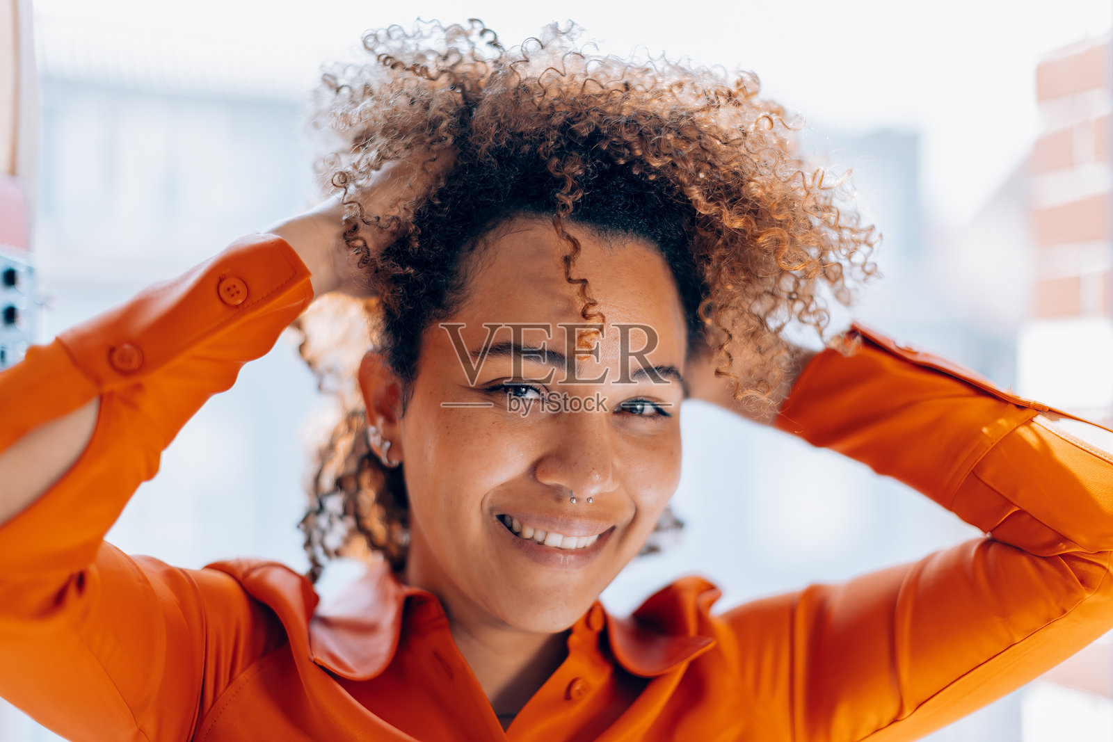 微笑的卷发女性在明亮的办公室里照片摄影图片