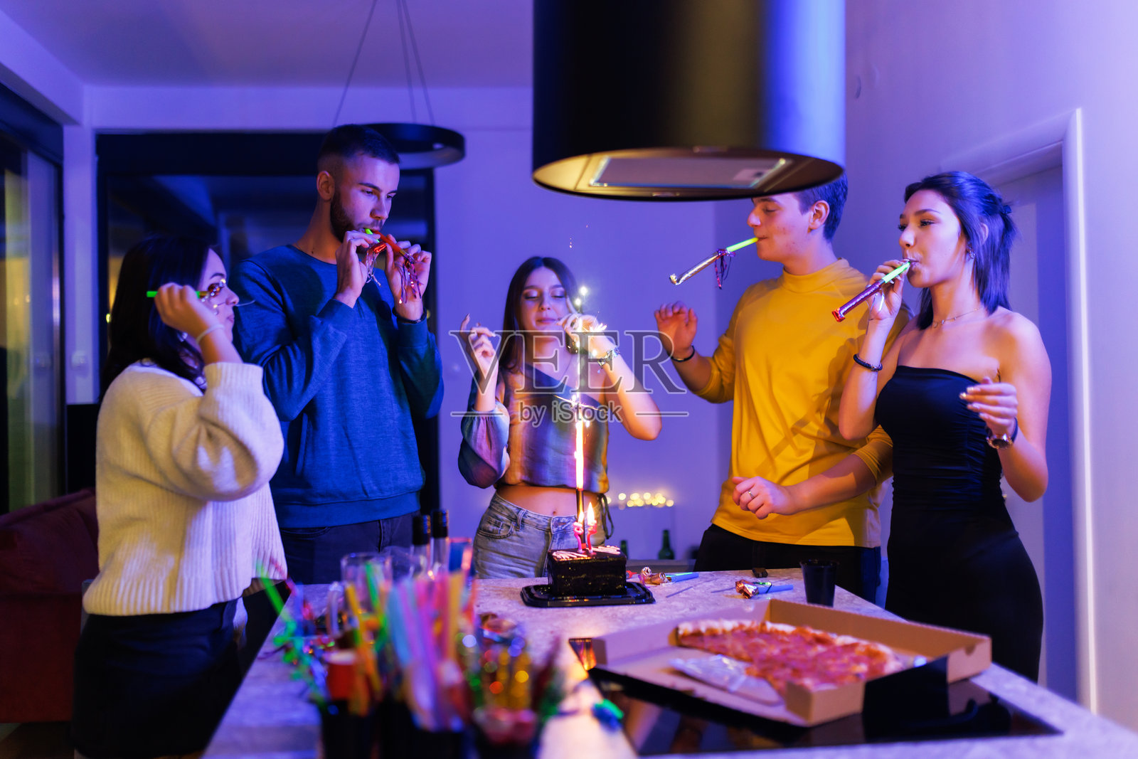朋友们在灯光绚丽的室内派对上庆祝照片摄影图片