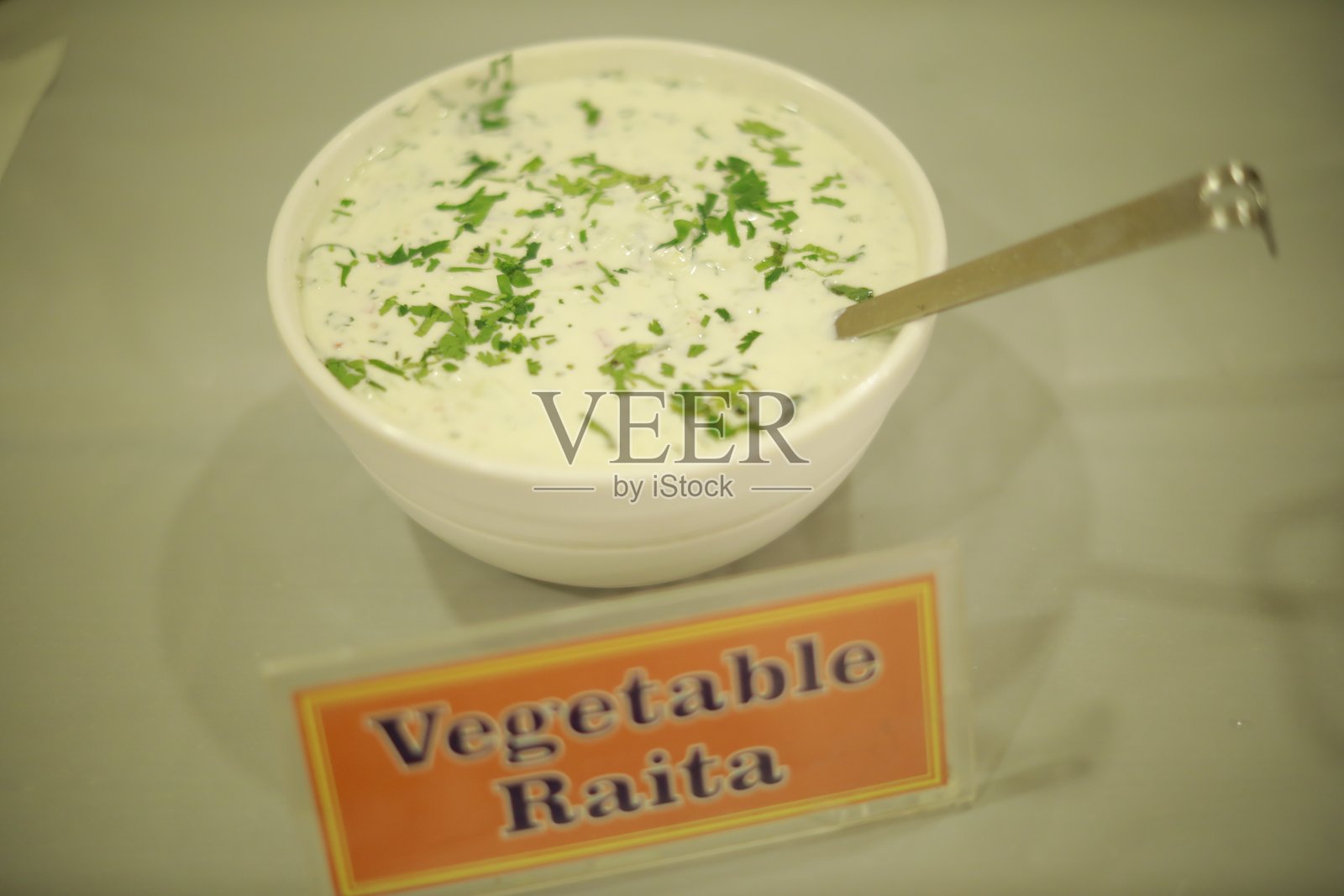 装有香菜装饰的蔬菜酸奶碗和餐具勺照片摄影图片