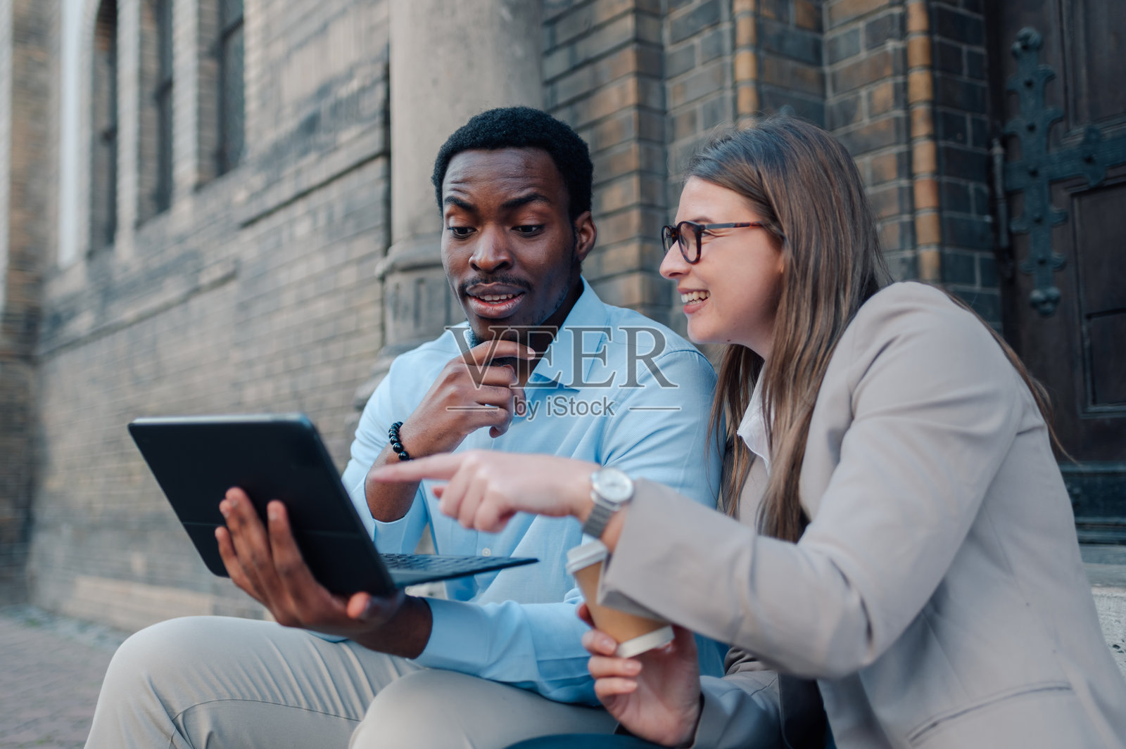 商务同事在户外讨论工作，使用数字平板电脑照片摄影图片