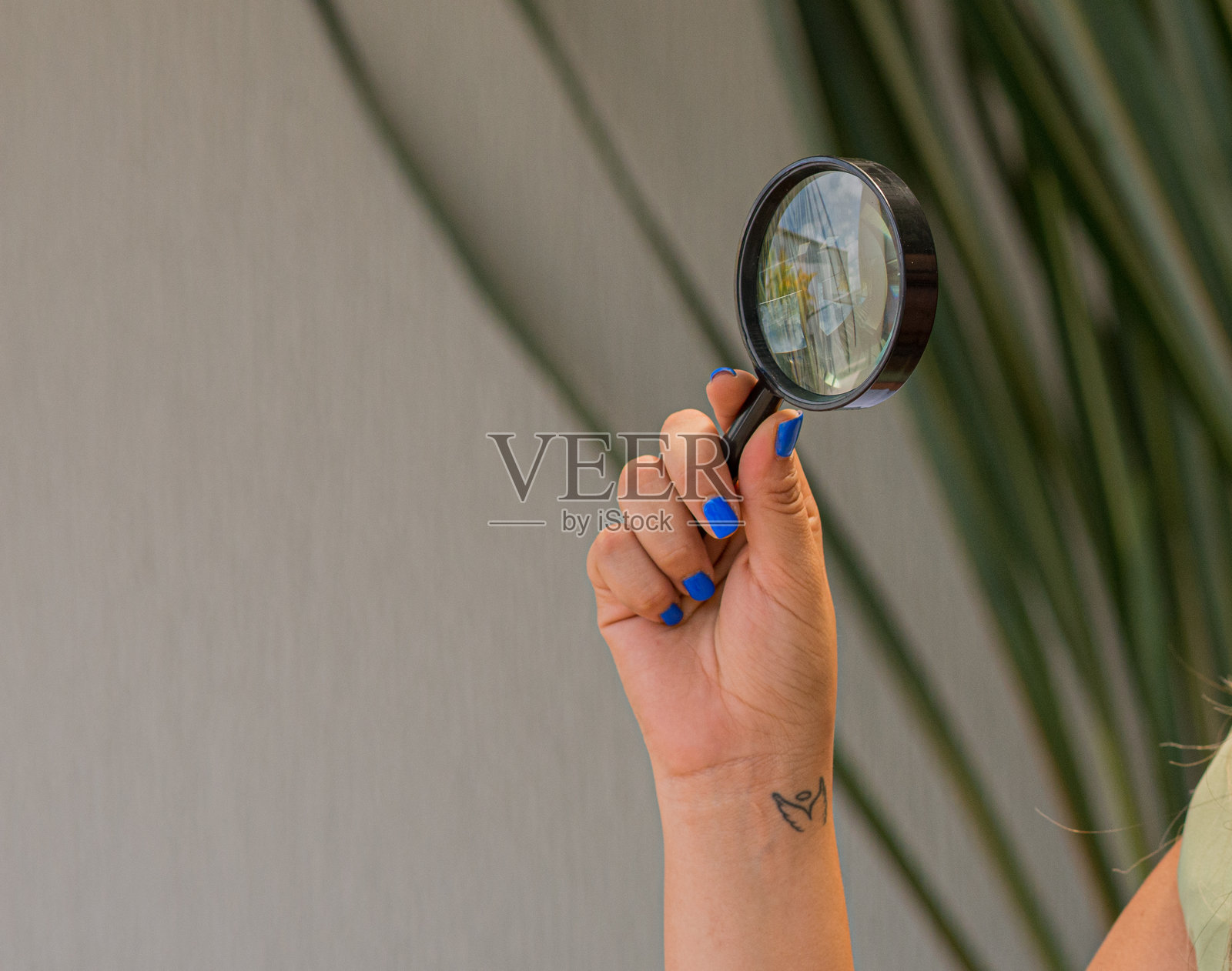 女性手持放大镜聚焦于目标，搜索与分析的概念。照片摄影图片