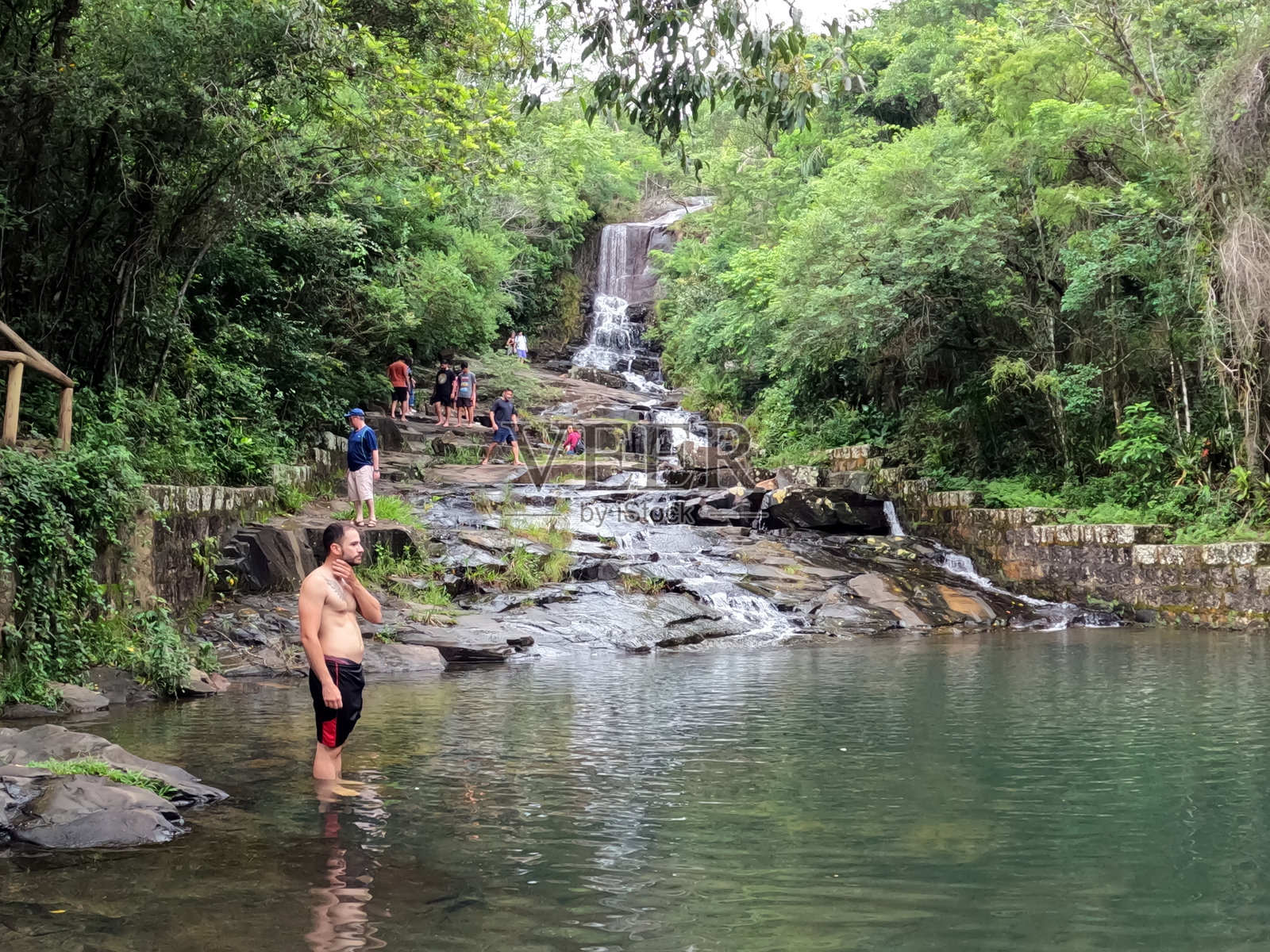 游客在“Costa da lagoa”享受瀑布的急流。照片摄影图片