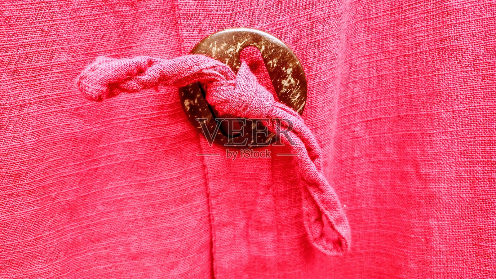 一款粉色夏季女装连衣裙，配有棕色时尚纽扣细节。照片摄影图片