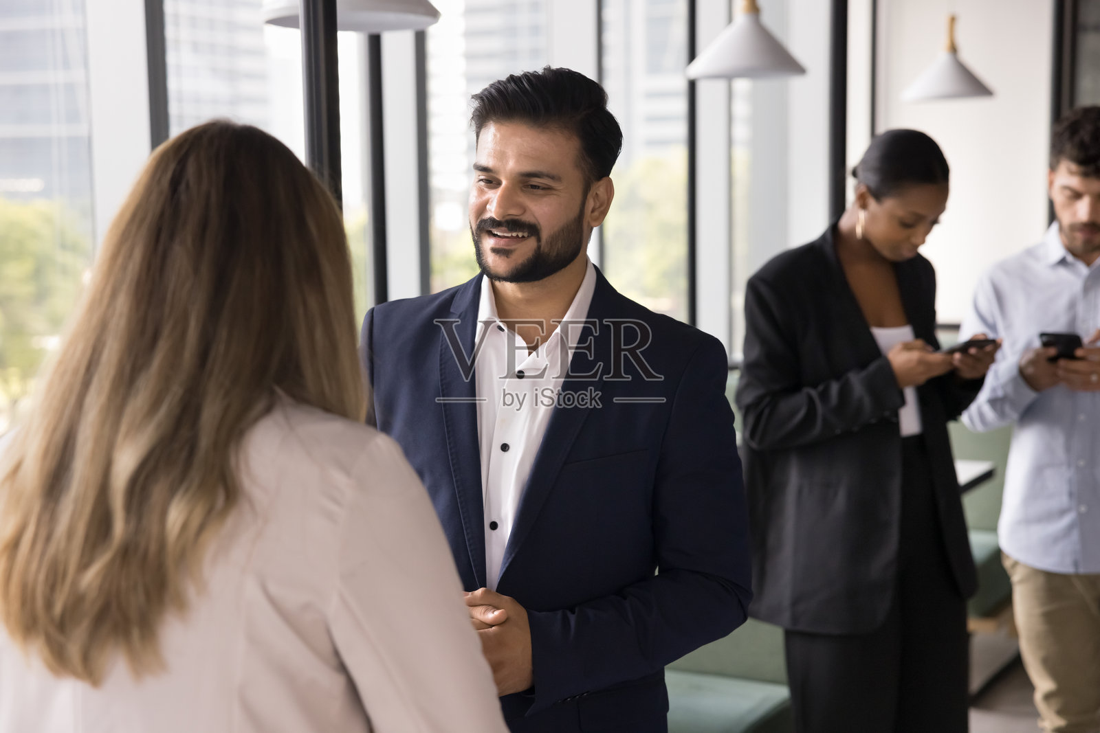 放松的多种族商务人士在小组中交谈或使用手机照片摄影图片