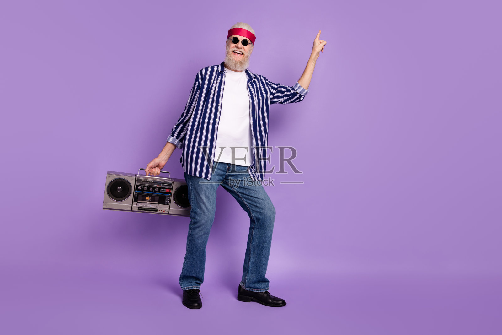 全身照，年长的疯狂男人开心地微笑，手持复古音乐的音响，在紫色背景下跳舞。照片摄影图片