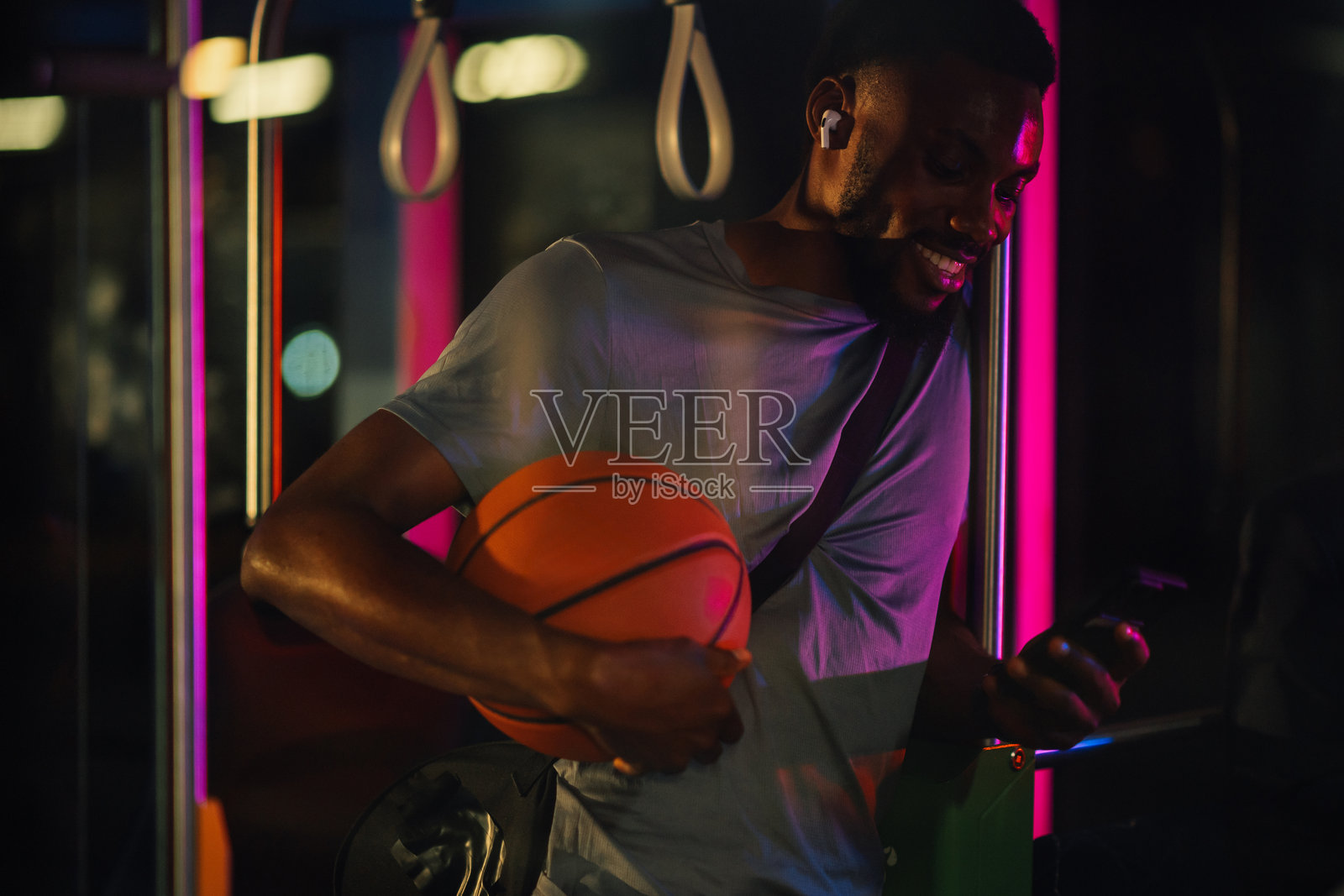 年轻的篮球运动员在夜间公共交通上使用智能手机照片摄影图片