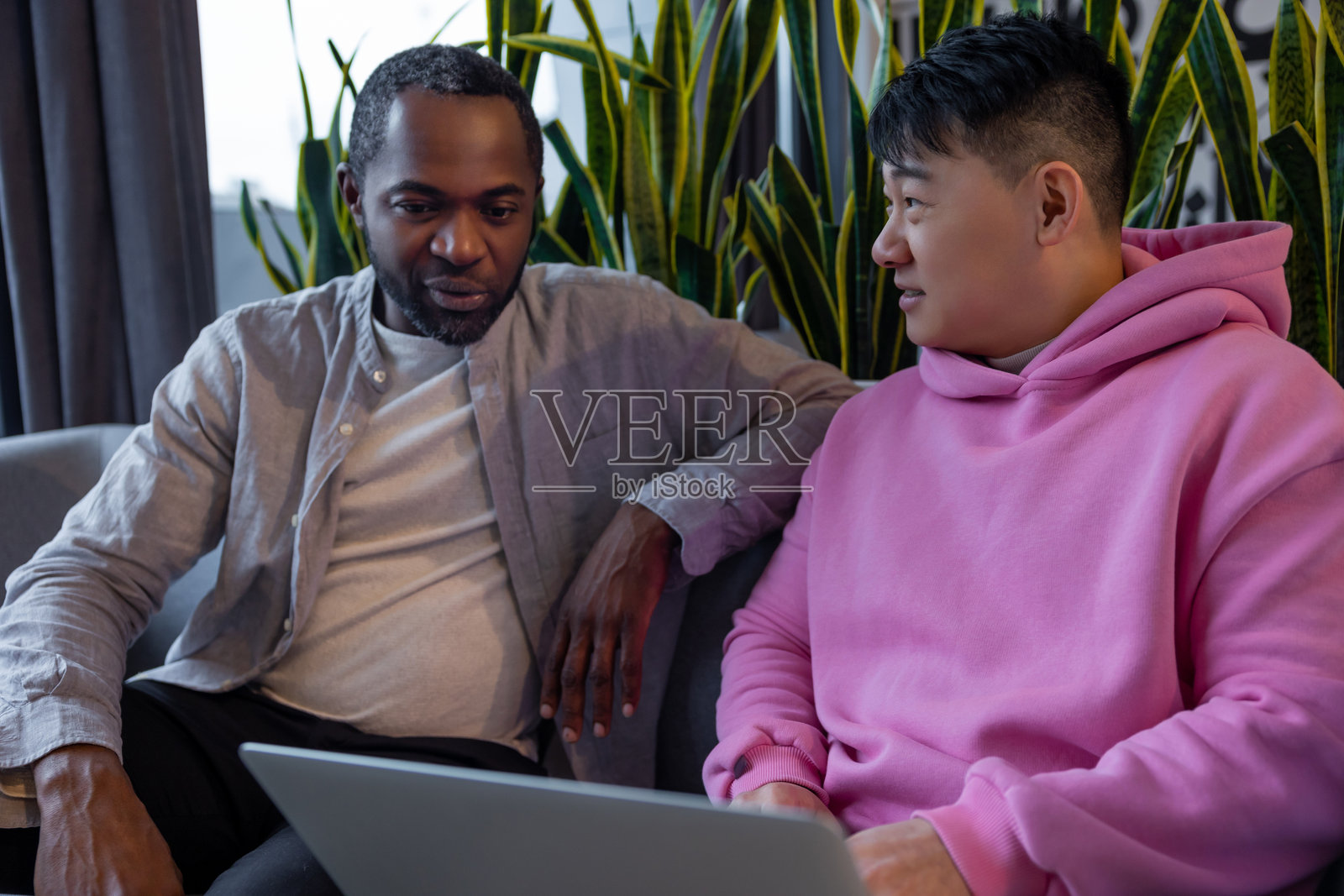 多元文化的商业伙伴在非正式工作空间中合作使用笔记本电脑照片摄影图片