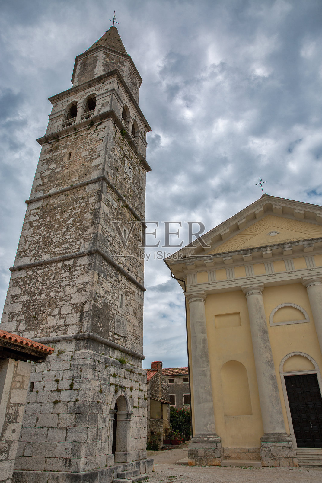 历史悠久的钟楼和教堂，背景是戏剧性的天空。克罗地亚，维斯尼扬。照片摄影图片