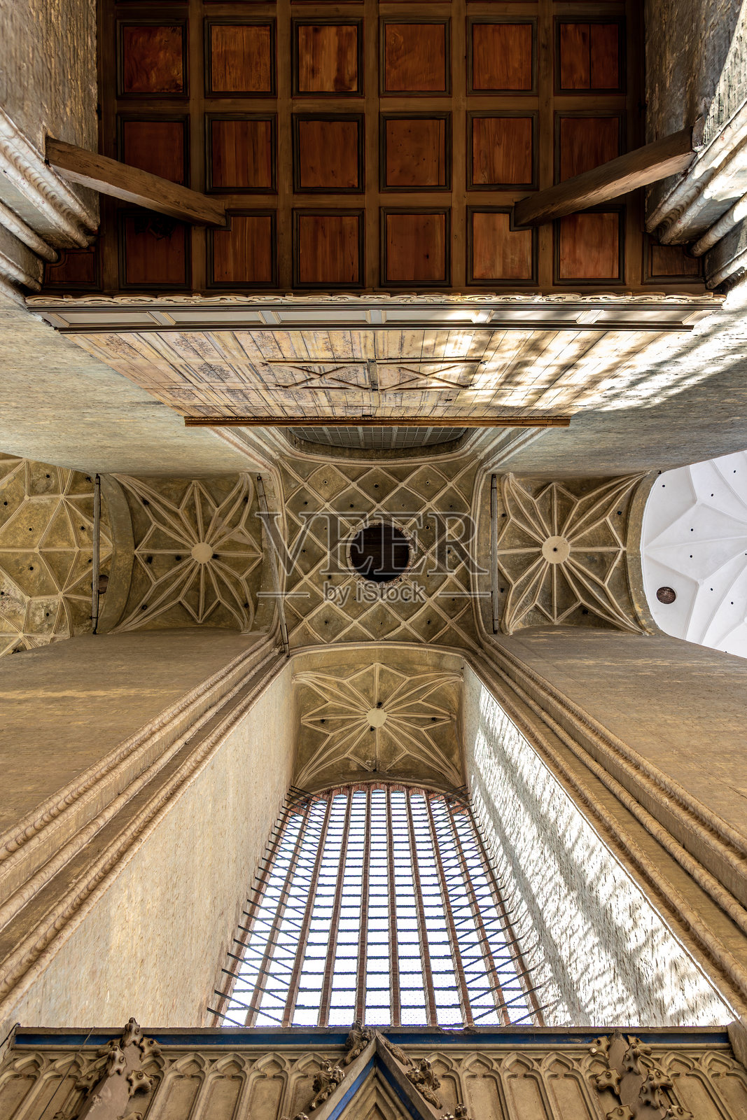 哥特式拱顶与木质面板。教堂内部的光与影。建筑遗产照片摄影图片
