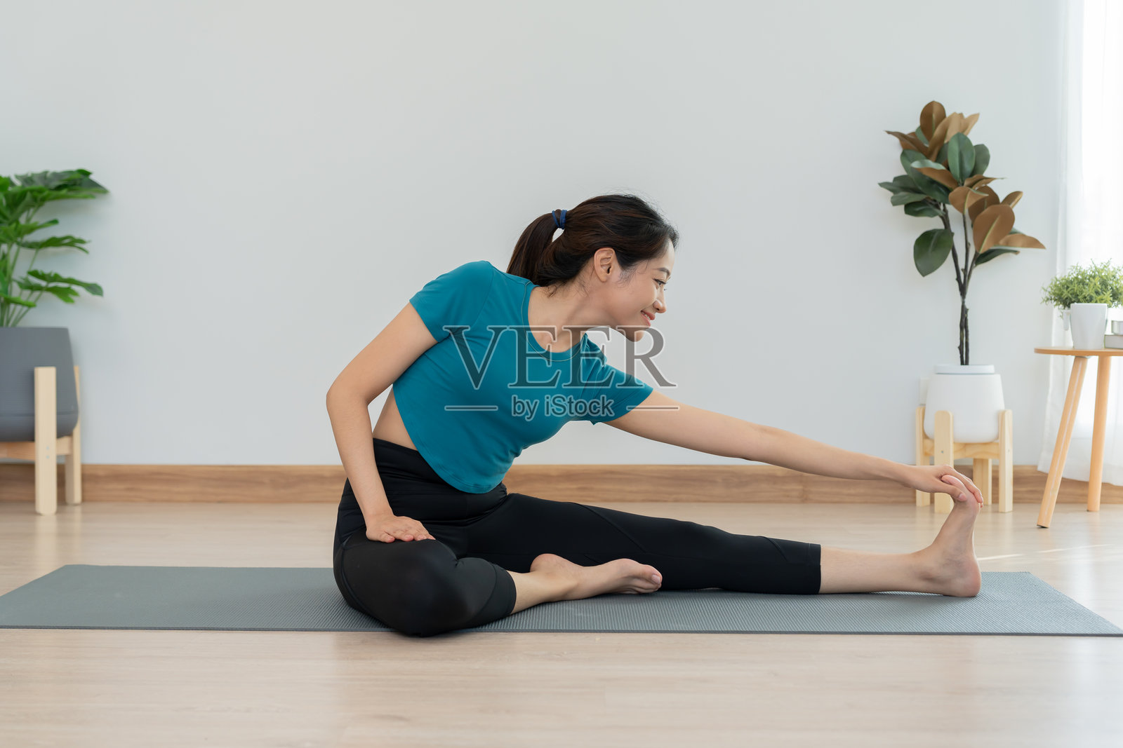 苗条的女性在公寓或家中练习瑜伽。亚洲女性在早晨进行锻炼。平衡、冥想、放松、宁静、健康、快乐、放松、健康生活方式、饮食、苗条。照片摄影图片