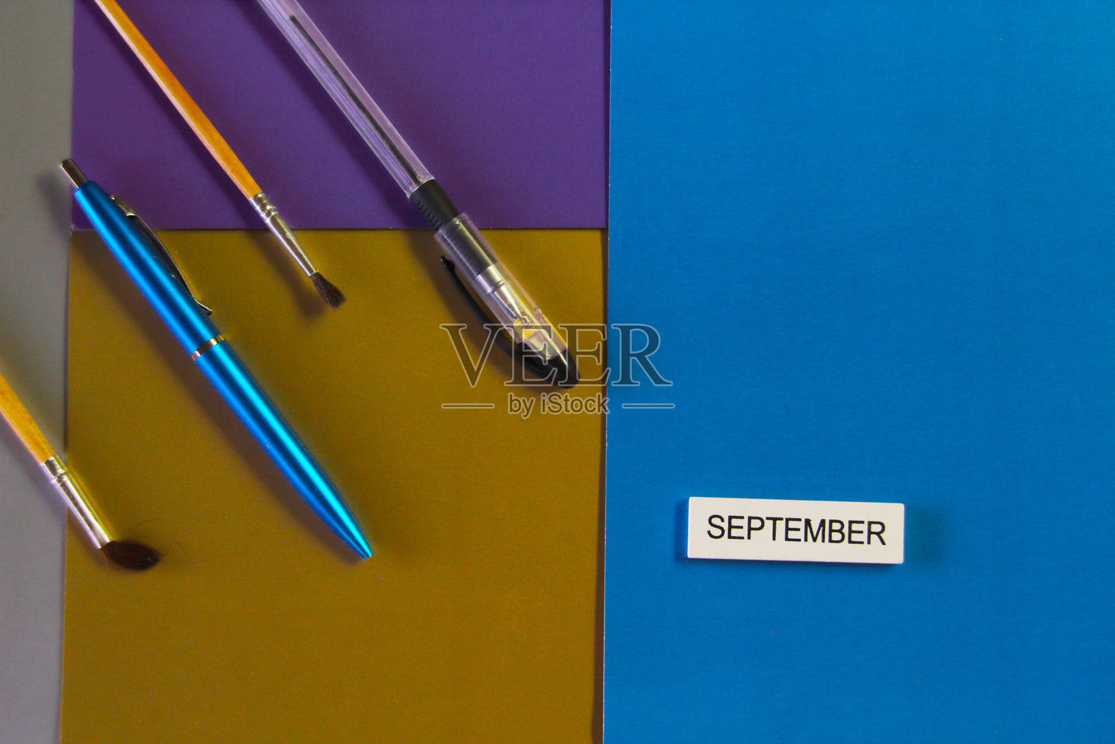 文具和写着“九月”的标志放在彩色纸板上。学习的概念。照片摄影图片