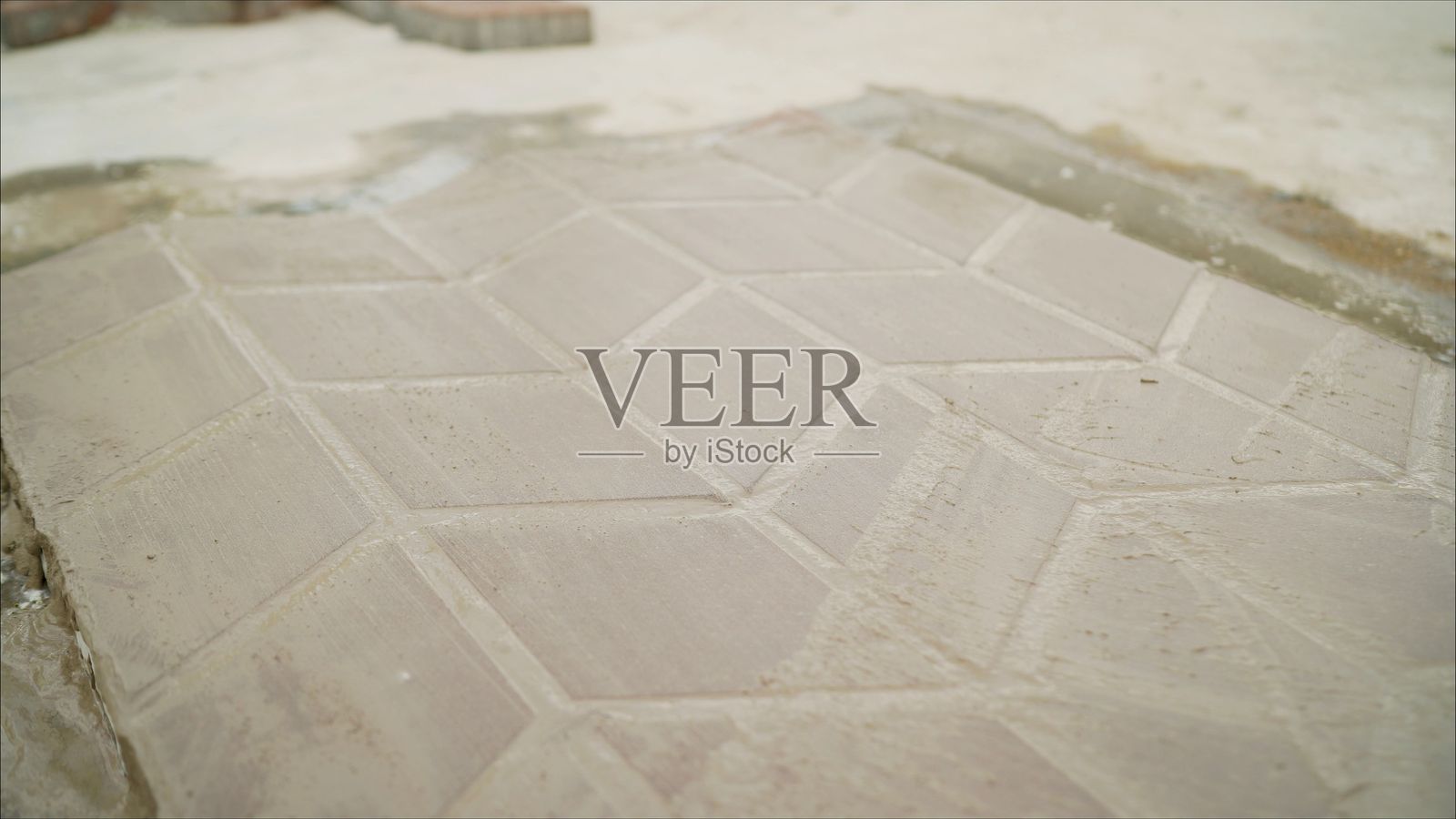 铺设铺路砖。铺设铺路砖时使用砂浆。工人用沙子和水泥找平基础。照片摄影图片