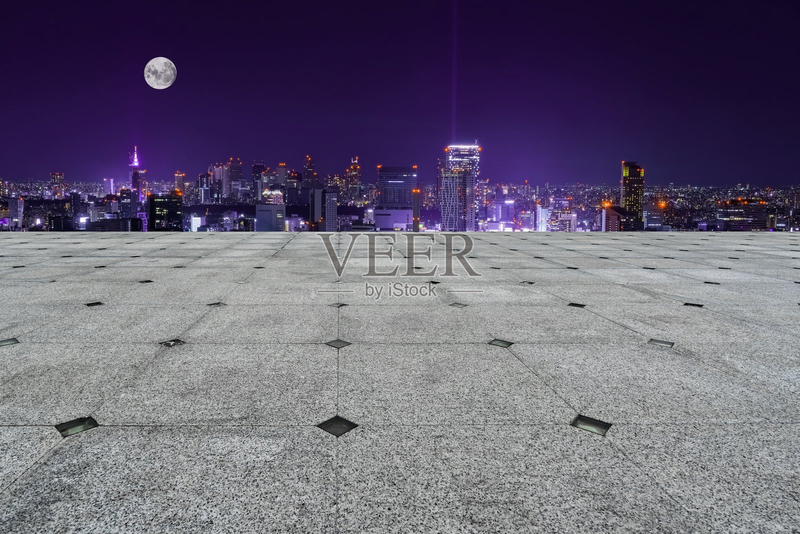 夜晚的月亮照耀着城市建筑，灯光映衬下的道路，户外景观，城市风光，旅行。照片摄影图片