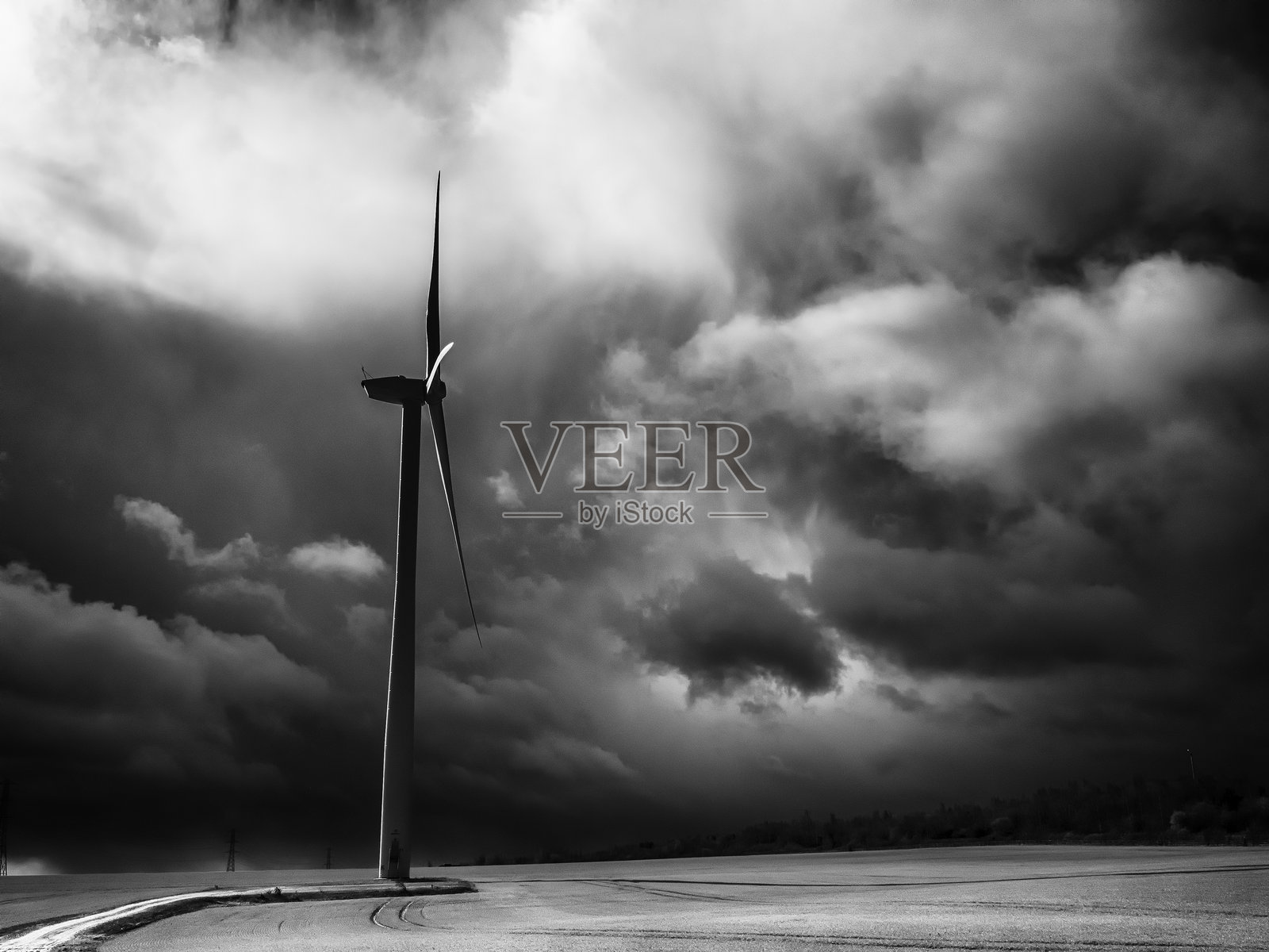 孤独的风力涡轮机矗立在北约克郡英格兰的田野中，背景是戏剧性的黑暗天空，黑白色调。照片摄影图片