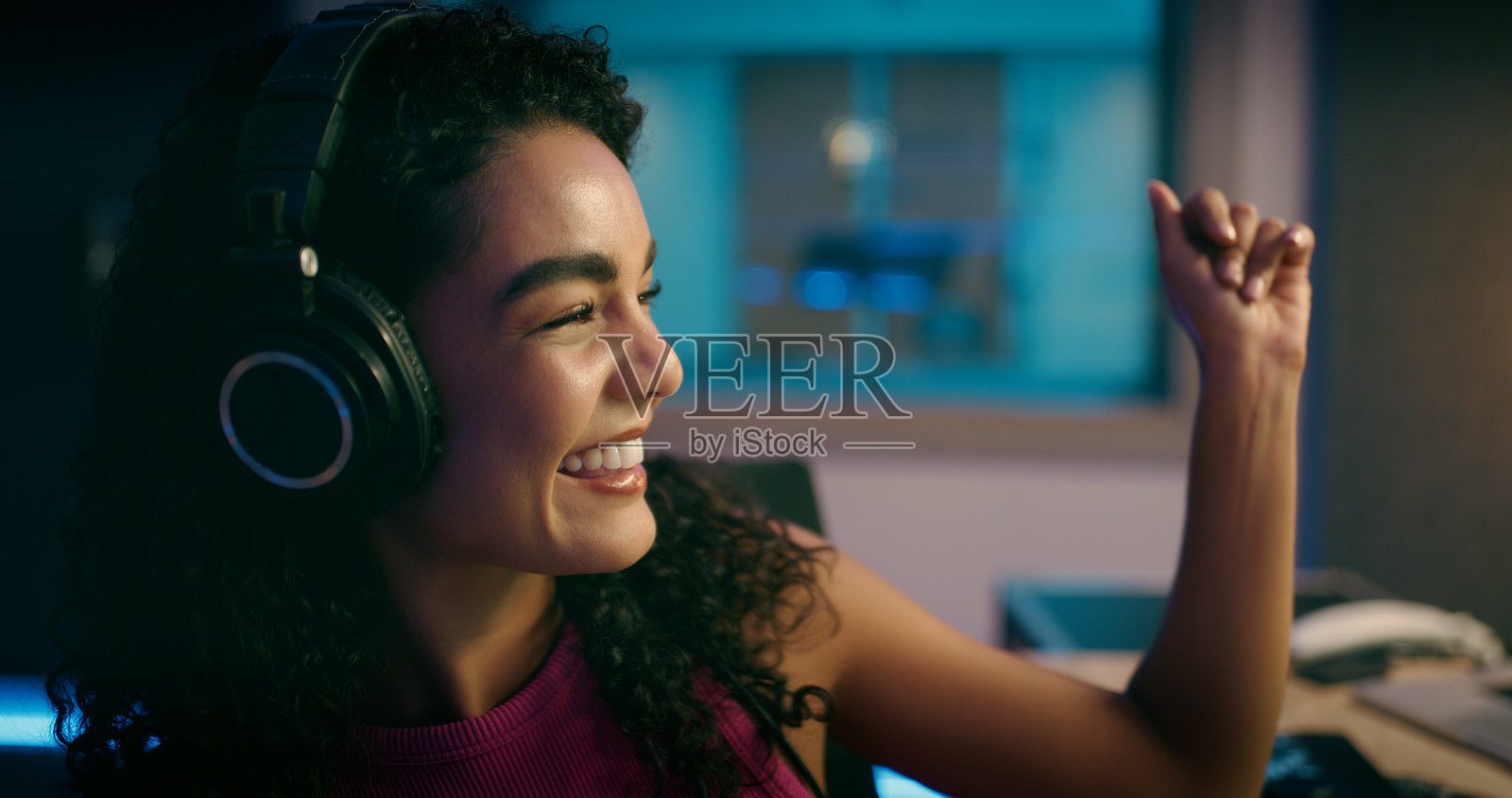 跳舞的女人，戴着耳机听音乐，夜晚或在网站上播放歌曲。快乐的人，订阅应用程序以获取播放列表，在家中享受乐趣或娱乐，收听广播或晚上。照片摄影图片