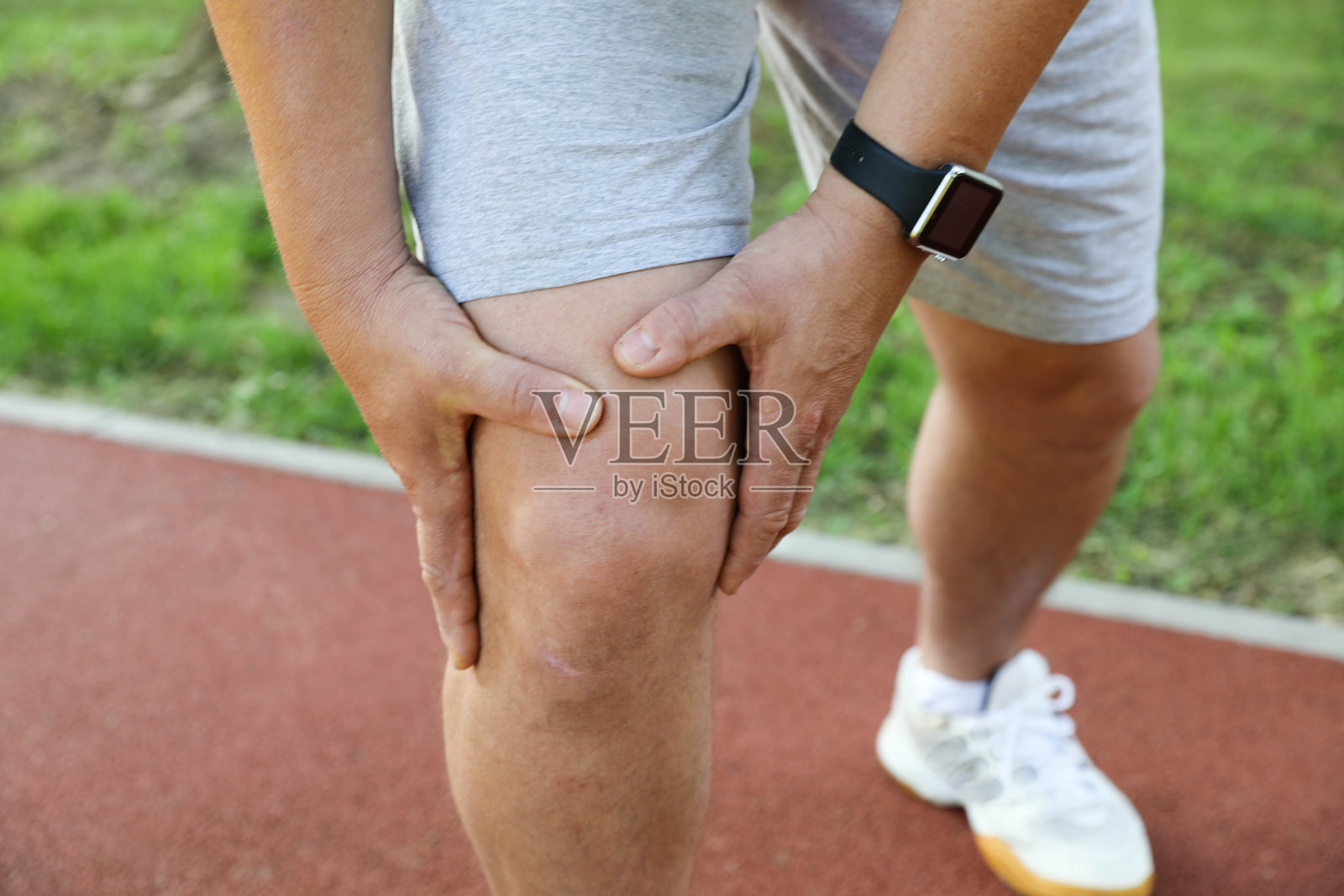 运动时触碰疼痛膝盖的男子照片摄影图片