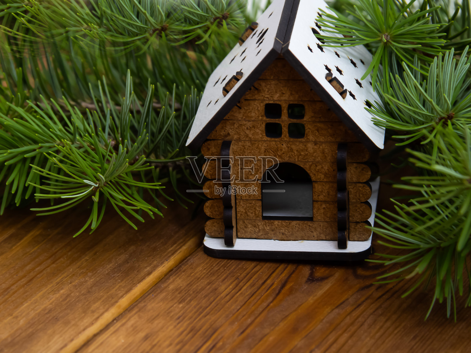 一座小木屋坐落在冷杉树枝上照片摄影图片