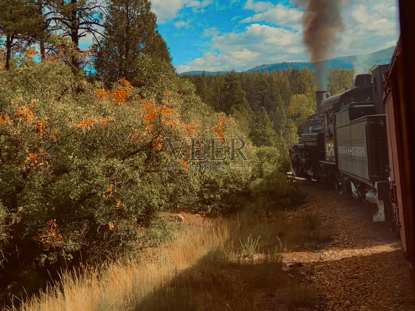 从客车视角看，复古蒸汽机车穿越森林田野，展现旧西部风格。照片摄影图片