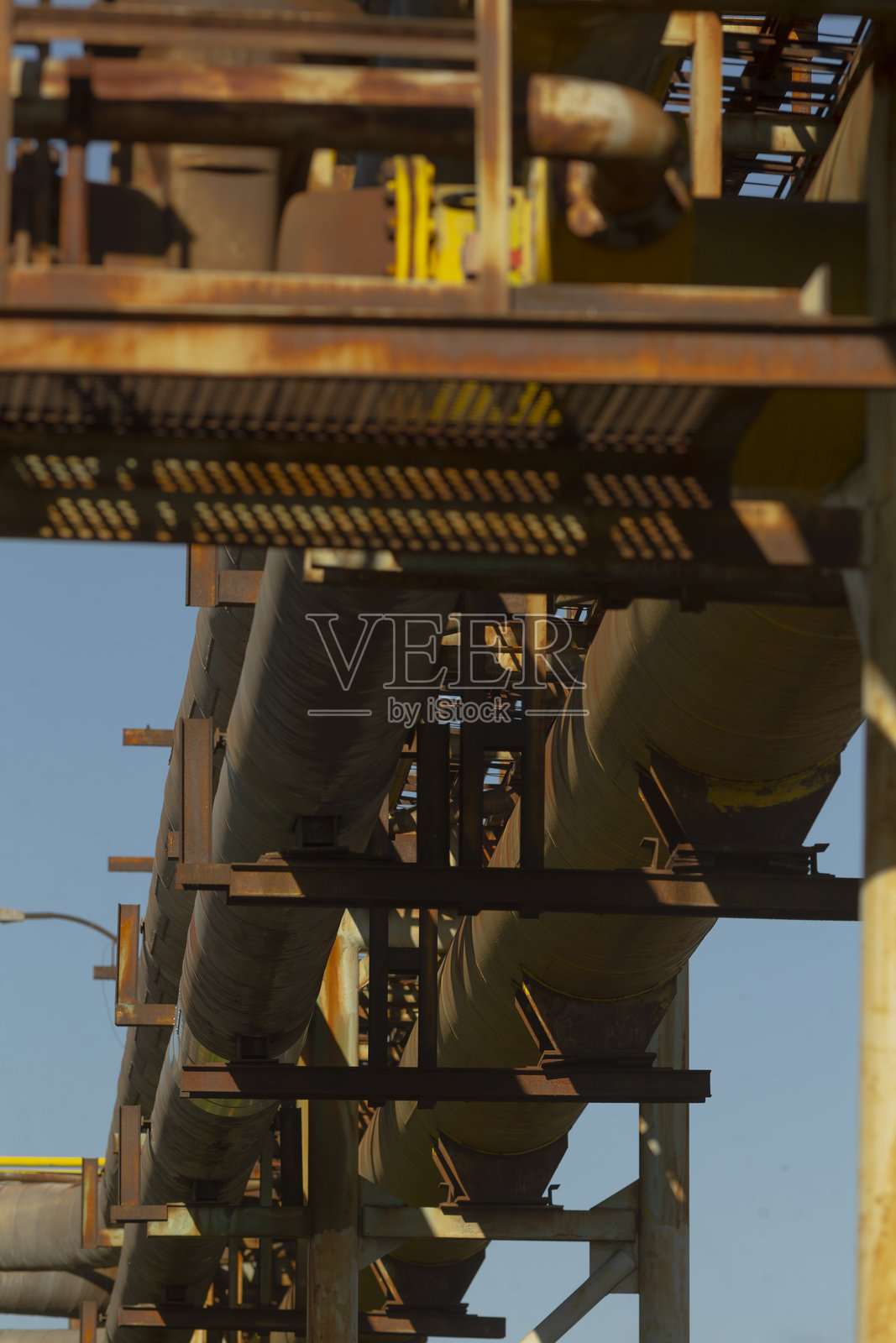 有几根管道悬挂在坚固的金属结构上。照片摄影图片