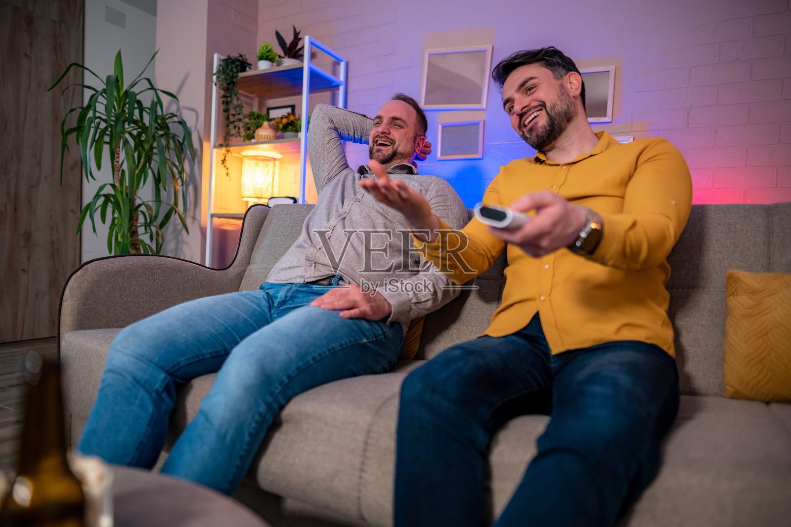 Friends enjoying a movie night at home in cozy setting照片摄影图片