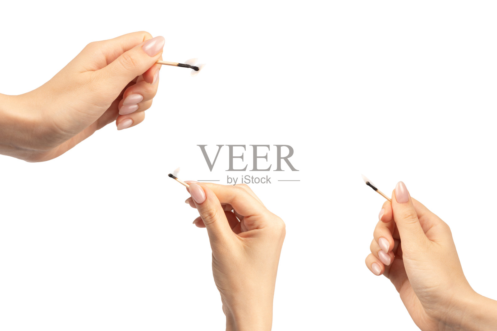 女人手中握着点燃的火柴，背景为白色。照片摄影图片