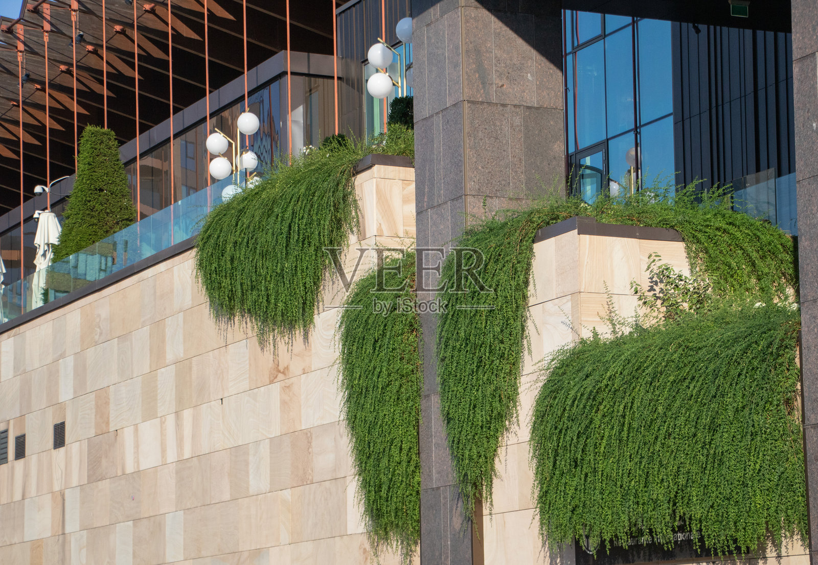 现代建筑外立面，配有垂直绿植和天然石墙照片摄影图片