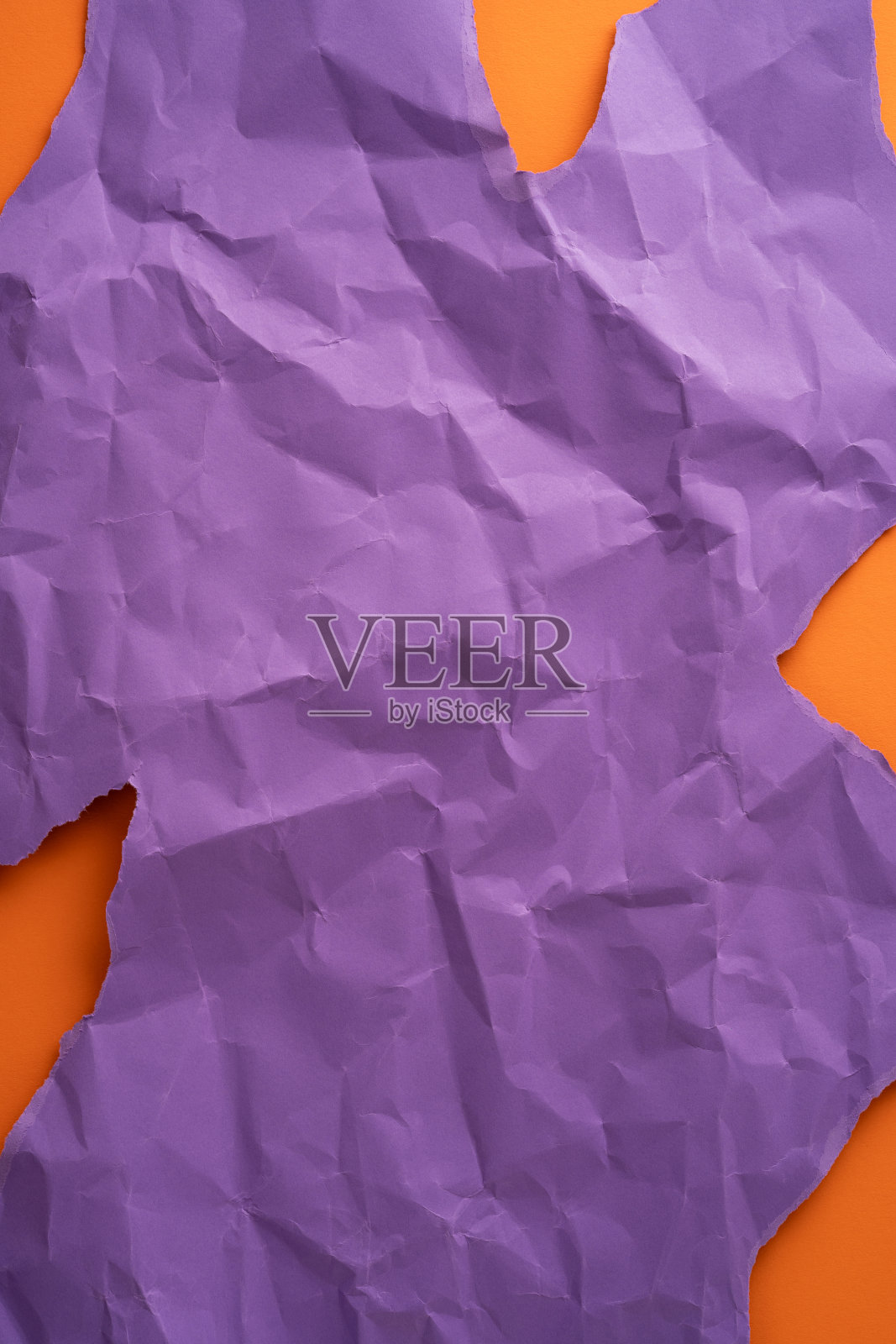 皱褶的紫色竖纸展现出鲜艳的橙色对比，突显出大胆的纹理和色彩。照片摄影图片