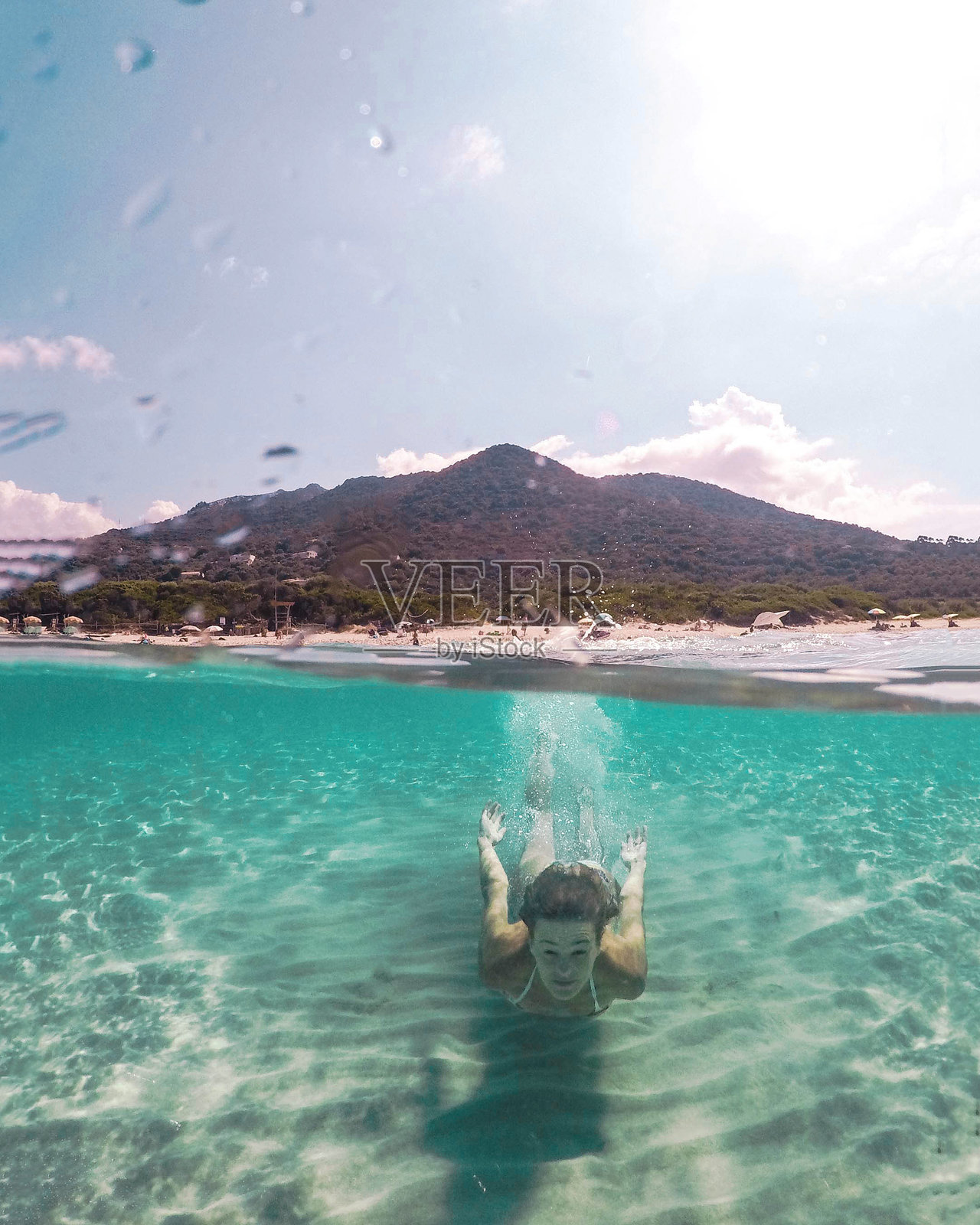 年轻女性在游泳池水下游向镜头。照片摄影图片