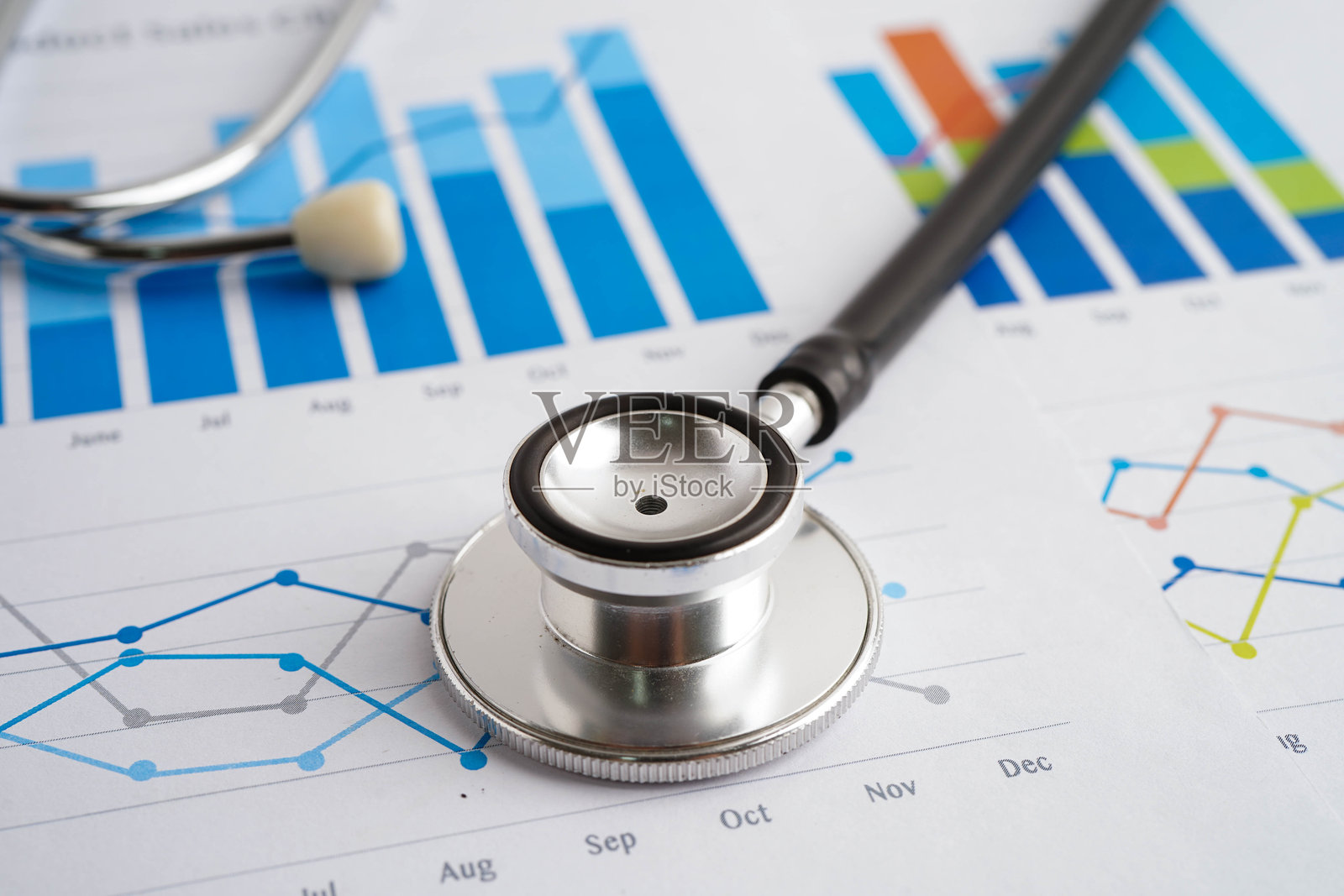 听诊器放在图表或图纸上，财务、账户、统计和商业数据医疗健康。照片摄影图片